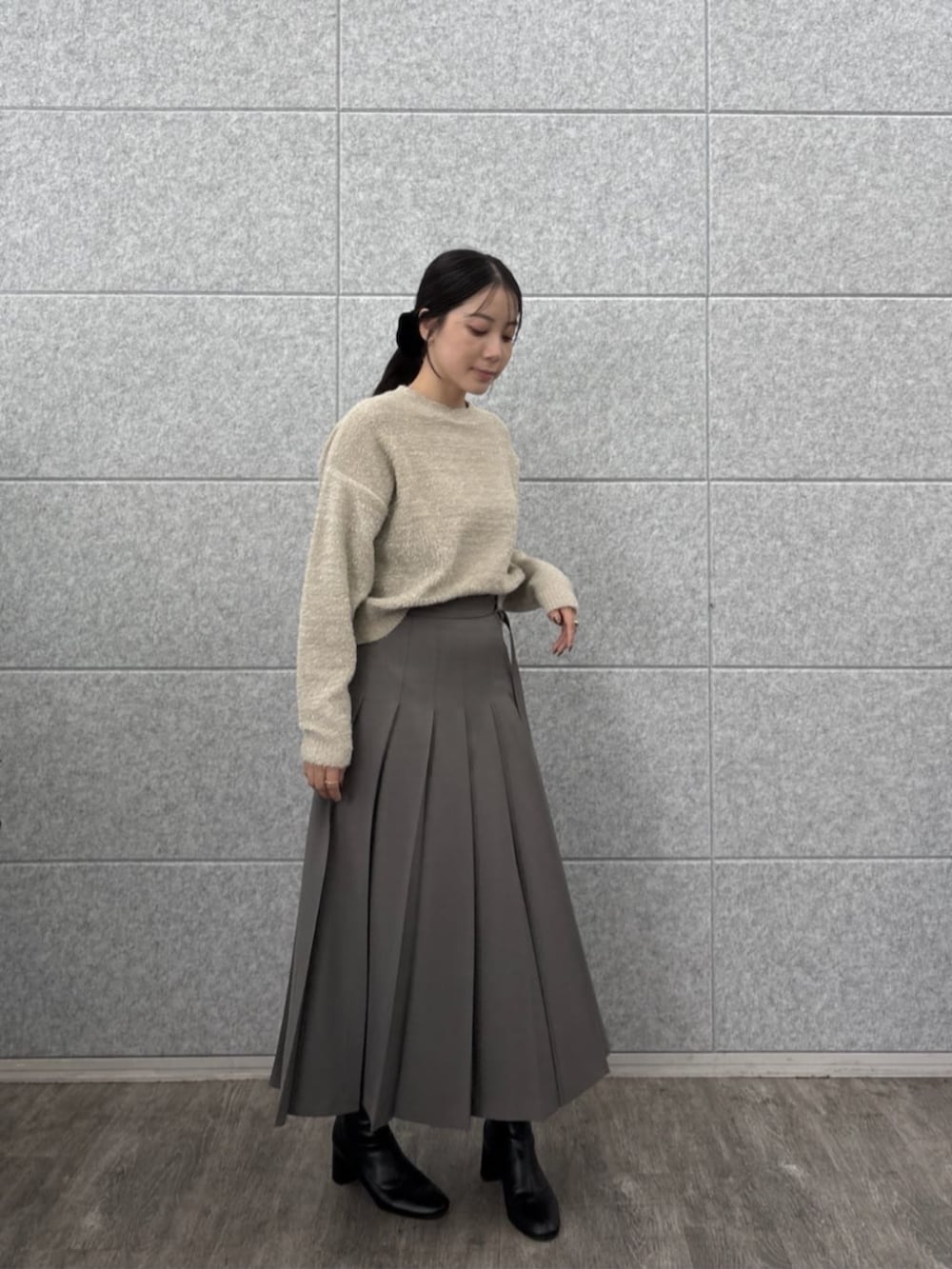ベージュ系のニット/セーター、グレー系のスカートを着用したレディースの秋コーディネートの2枚目の写真
