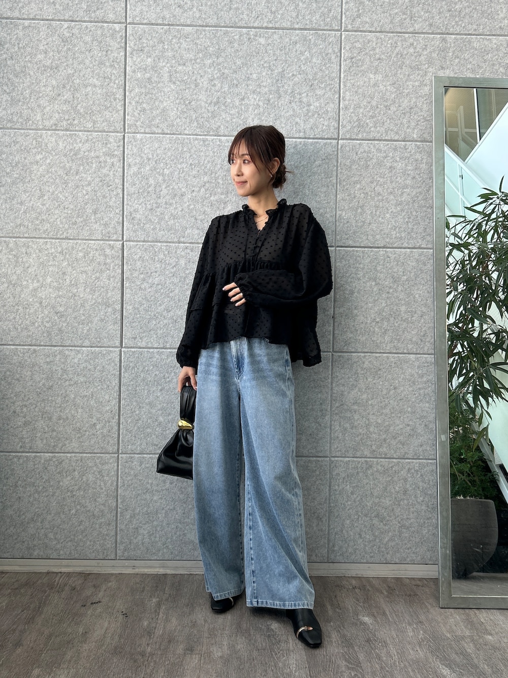 ブラック系のシャツ/ブラウス、ブルー系のデニムパンツを着用したレディースの夏コーディネートの2枚目の写真