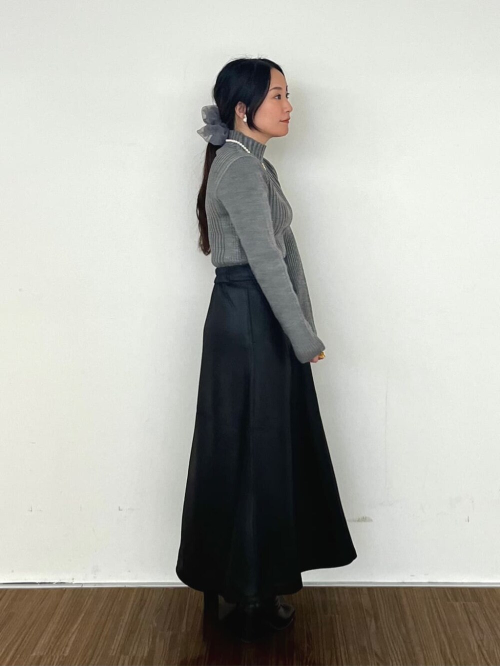 ブラック系のスカート、グレー系のニット/セーターを着用したレディースの冬コーディネートの3枚目の写真