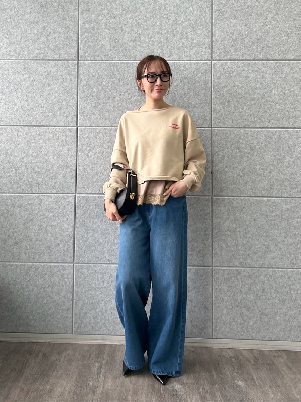 ベージュ系のスウェット、ブルー系のデニムパンツを着用したレディースの冬コーディネートの2枚目の写真