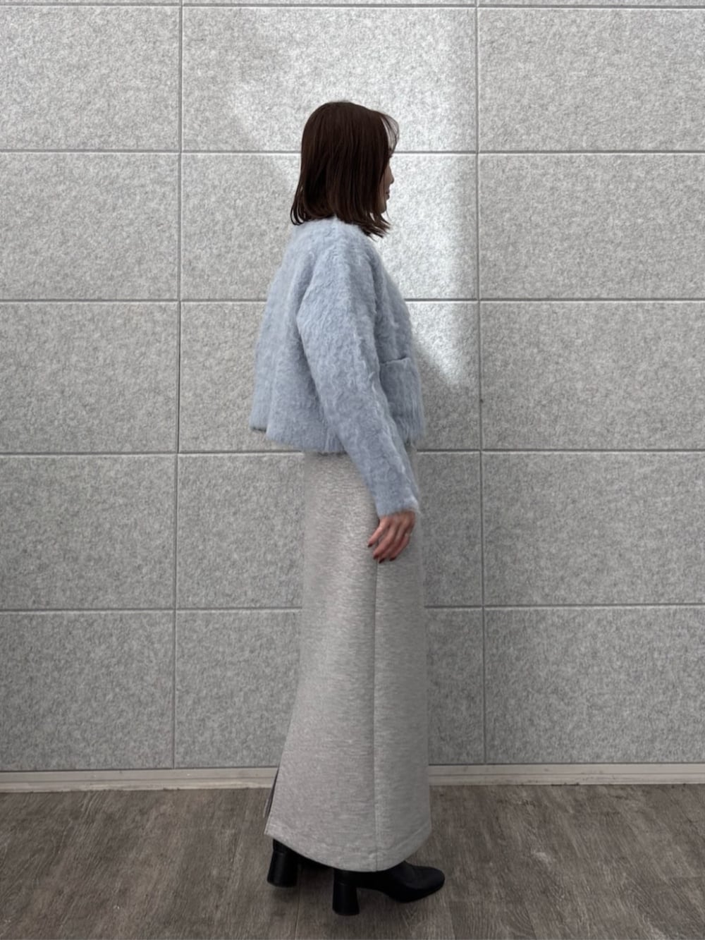 グレー系のスカート、グレー系のニット/セーター、ブルー系のカーディガン/ボレロを着用したレディースの秋コーディネートの5枚目の写真