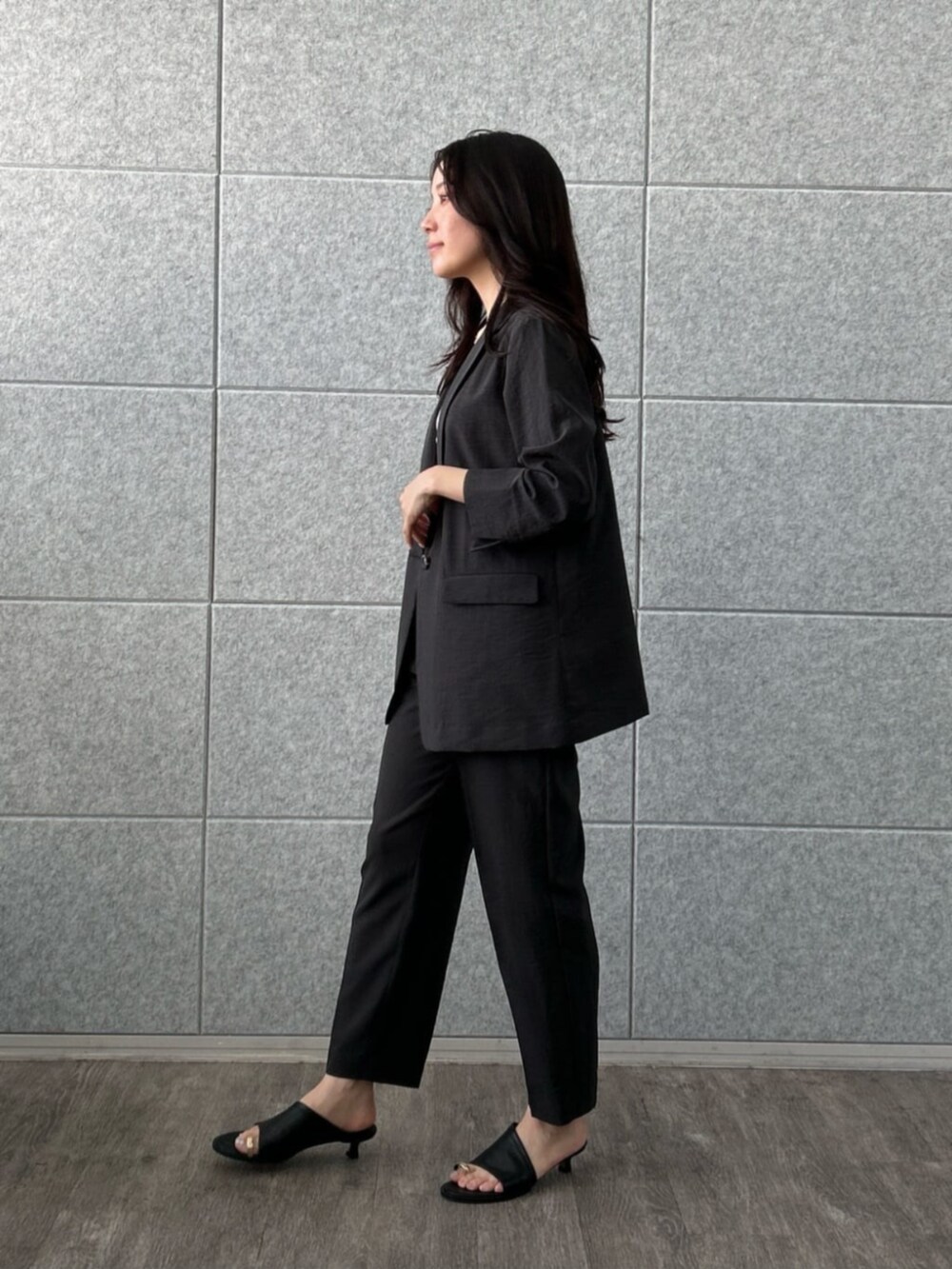 ホワイト系のタンクトップ、ブラック系のテーラードジャケット、ブラック系のその他パンツを着用したレディースの夏コーディネートの3枚目の写真