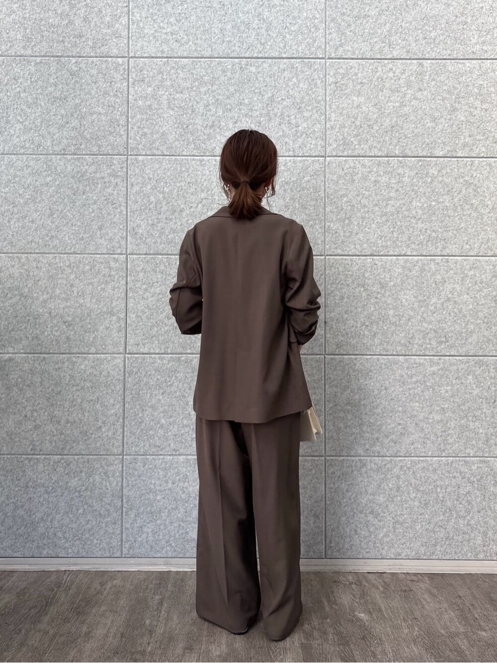 ブラウン系のテーラードジャケット、ブラウン系のその他パンツ、ホワイト系のTシャツ/カットソーを着用したレディースの秋コーディネートの3枚目の写真