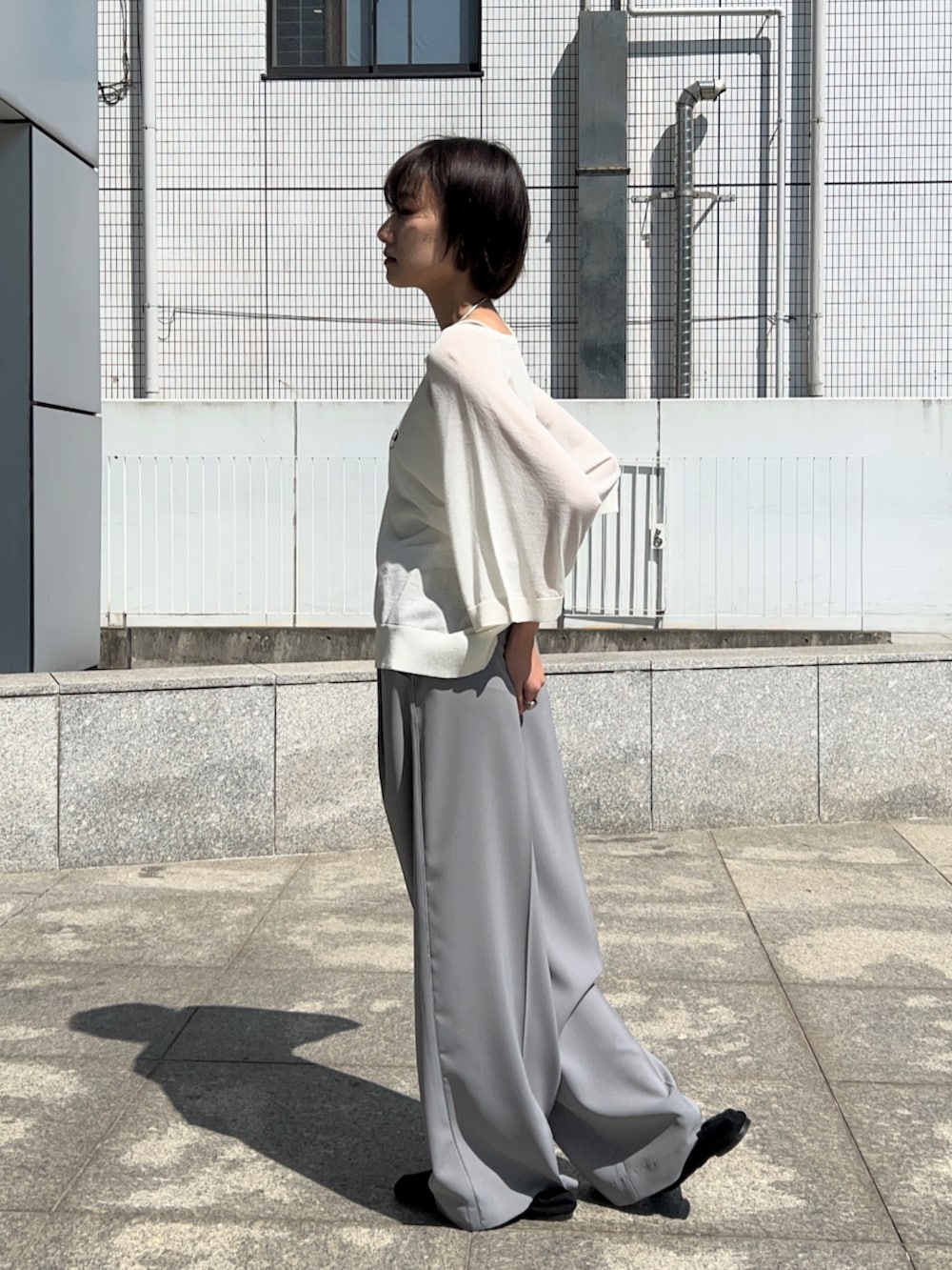 グレー系のその他パンツ、ホワイト系のニット/セーターを着用したレディースの春コーディネートの7枚目の写真