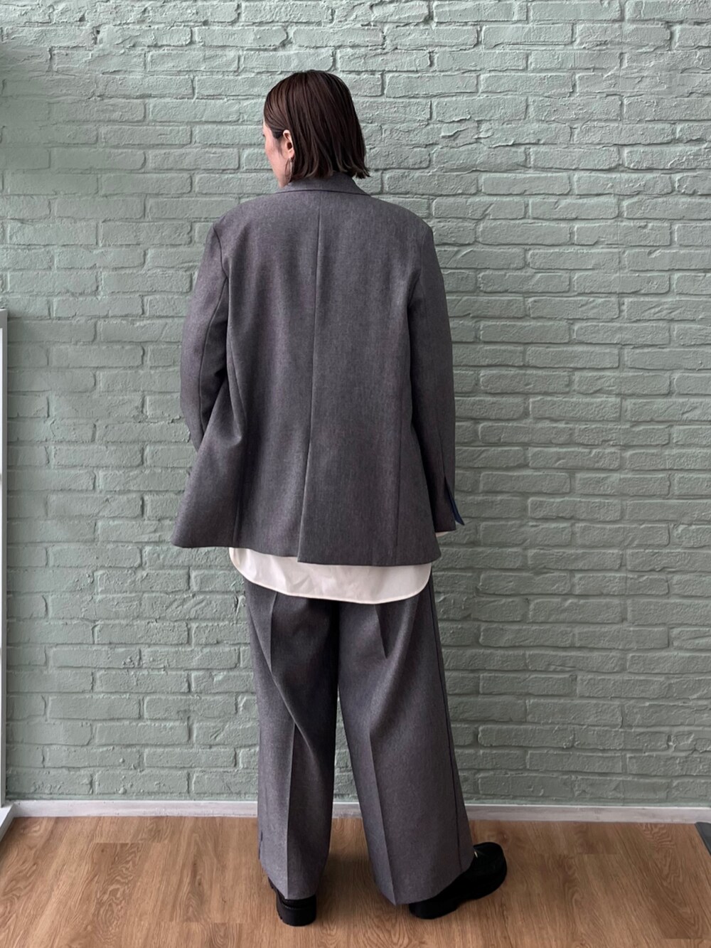 グレー系のテーラードジャケット、グレー系のその他パンツ、グレー系のニット/セーターを着用したレディースの秋コーディネートの4枚目の写真