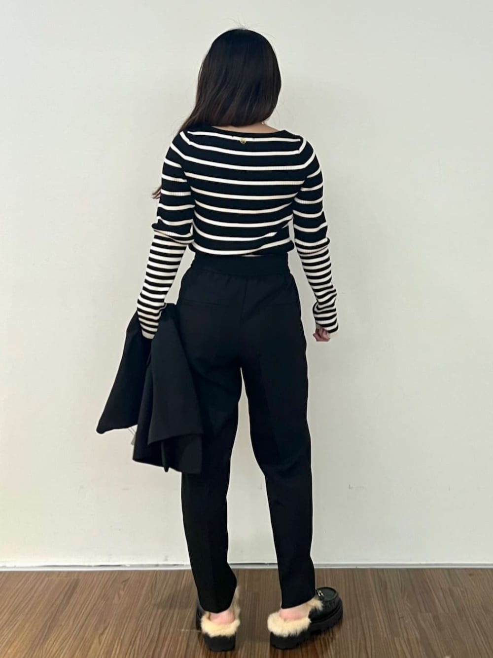 ブラック系のニット/セーター、ブラック系のその他パンツ、ブラック系のベストを着用したレディースの秋コーディネートの4枚目の写真