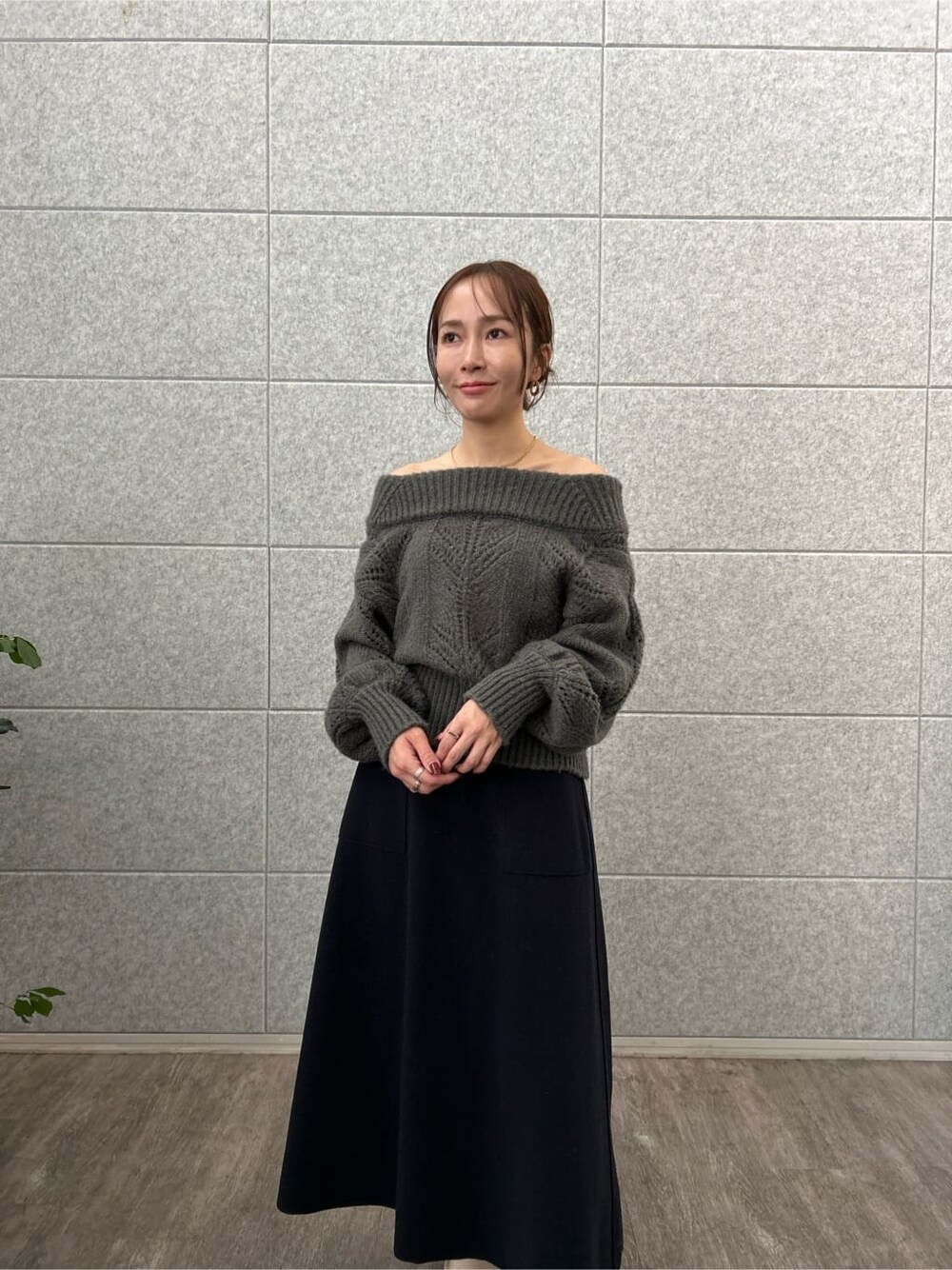 グレー系のニット/セーター、イエロー系のスカートを着用したレディースの秋コーディネートの5枚目の写真