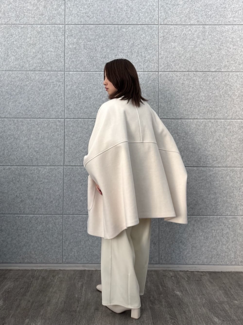 ホワイト系のその他パンツ、ホワイト系のその他アウター、ゴールド系のニット/セーターを着用したレディースの秋コーディネートの4枚目の写真