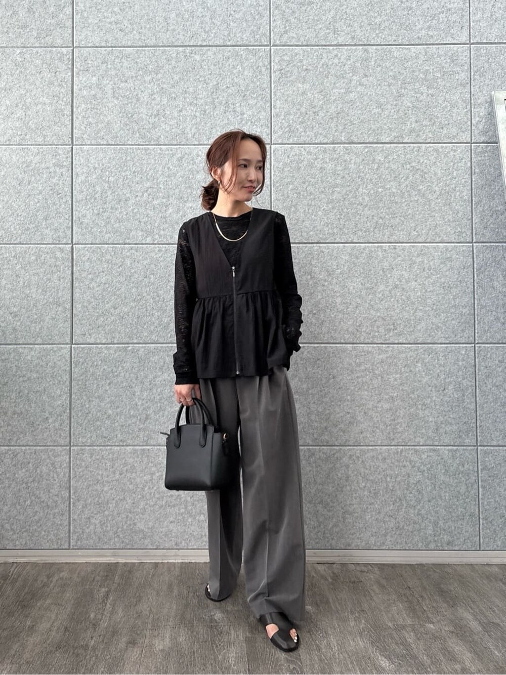ブラック系のTシャツ/カットソー、ブラック系のベスト、グレー系のその他パンツを着用したレディースの秋コーディネートの7枚目の写真