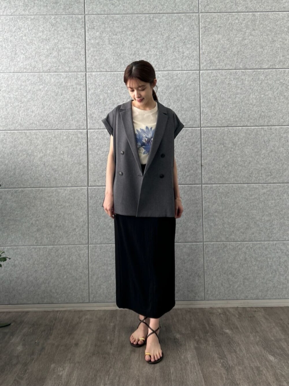 ブラック系のスカート、グレー系のテーラードジャケット、ベージュ系のTシャツ/カットソーを着用したレディースの夏コーディネートの3枚目の写真