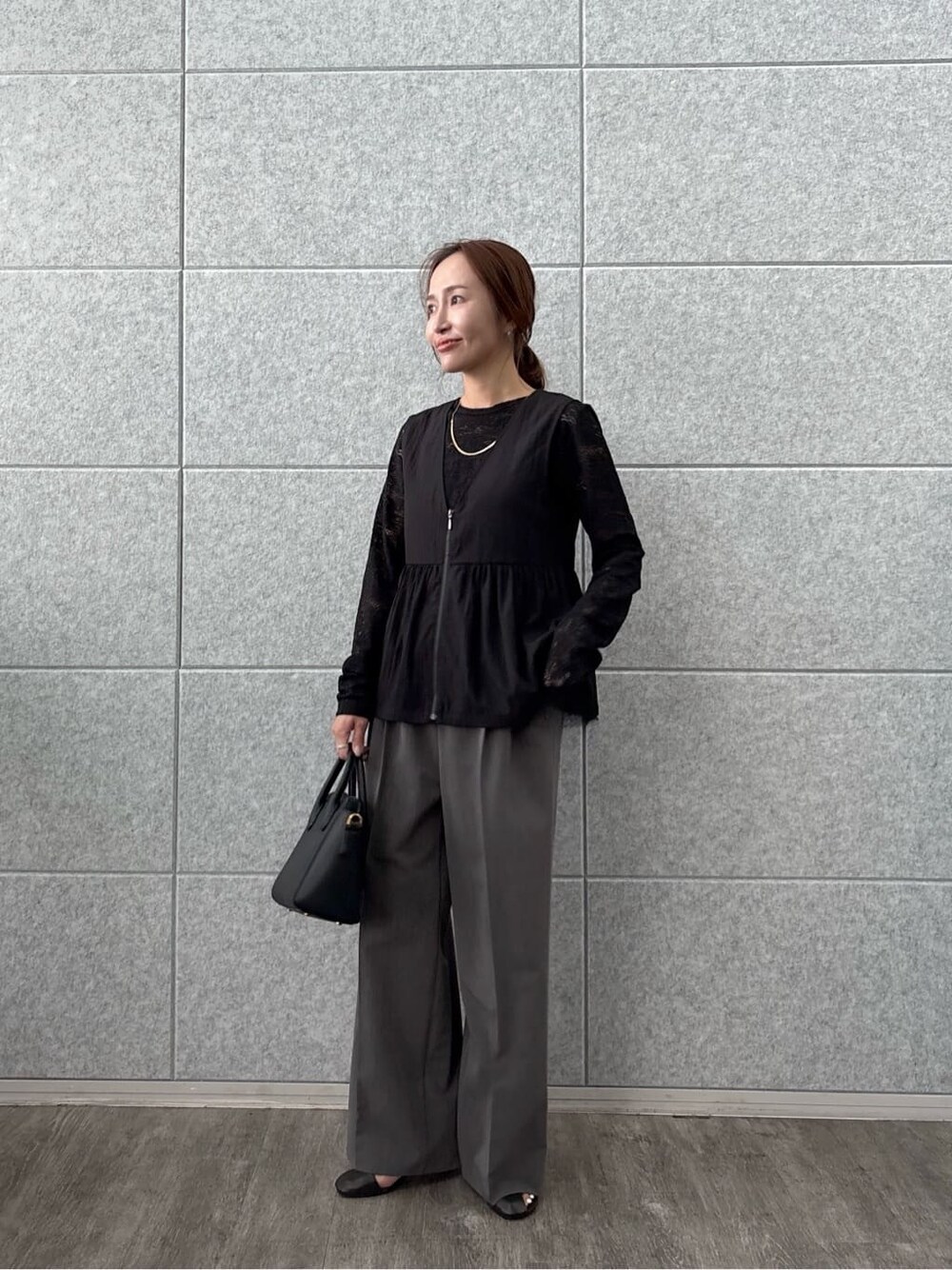 ブラック系のTシャツ/カットソー、ブラック系のベスト、グレー系のその他パンツを着用したレディースの秋コーディネートの2枚目の写真