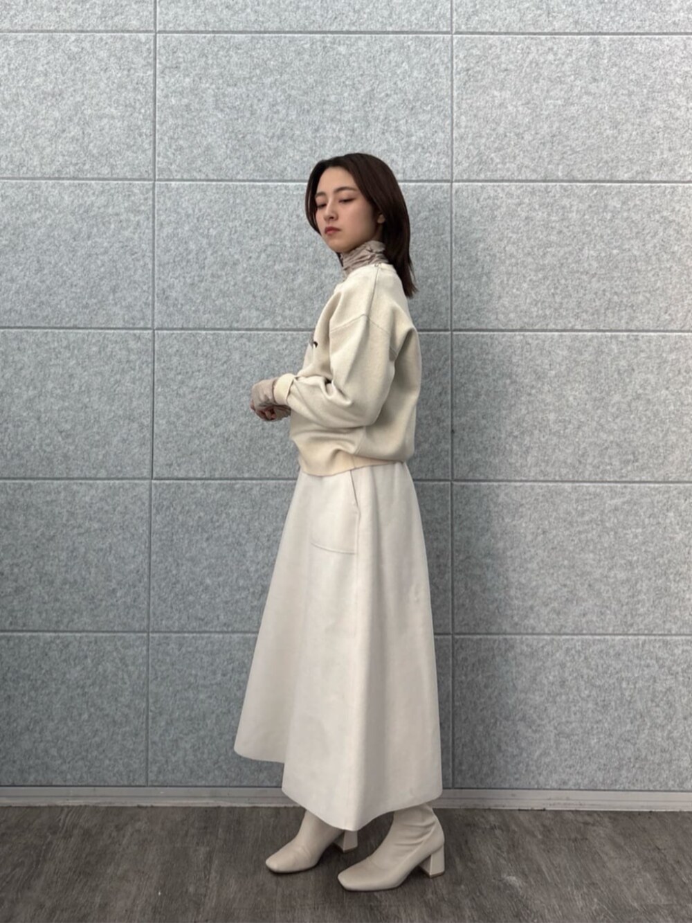 ホワイト系のスカート、ホワイト系のニット/セーター、ベージュ系のTシャツ/カットソーを着用したレディースの秋コーディネートの5枚目の写真