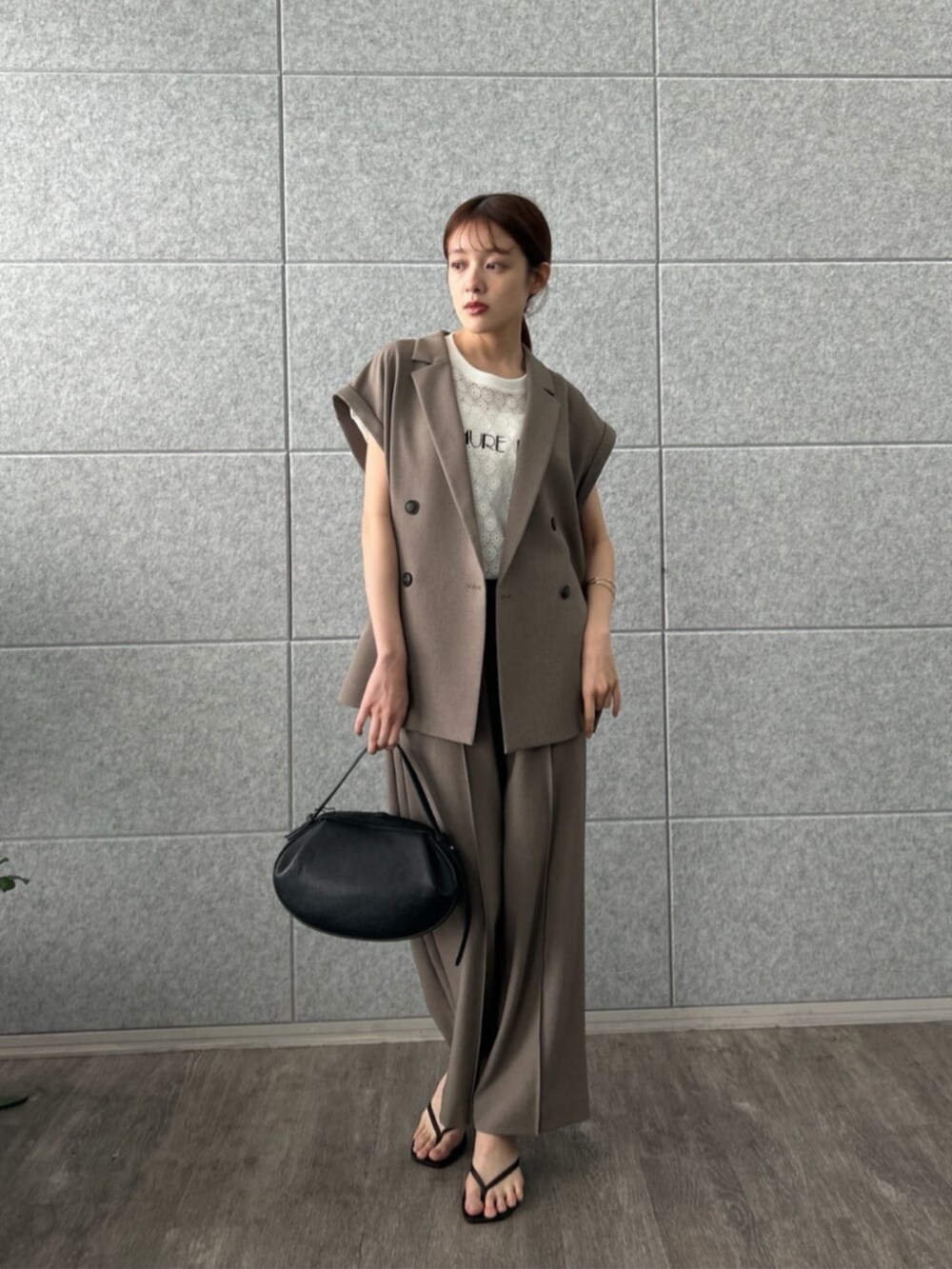 ブラウン系のテーラードジャケット、ブラウン系のその他パンツ、ホワイト系のTシャツ/カットソーを着用したレディースの夏コーディネートの3枚目の写真