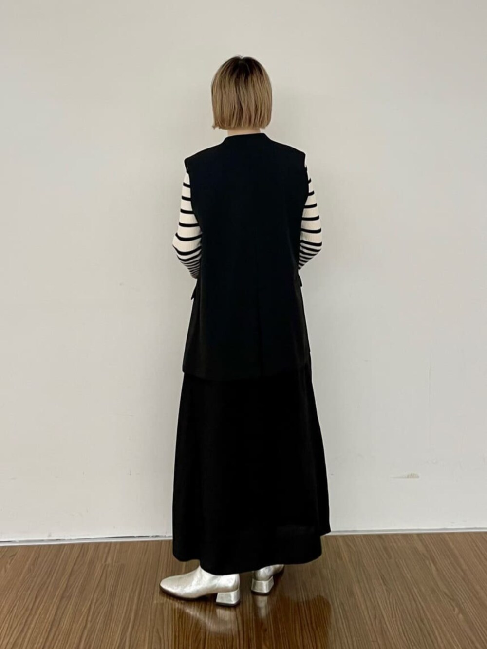 ブラック系のワンピース、ベージュ系のニット/セーター、ブラック系のベストを着用したレディースの秋コーディネートの4枚目の写真