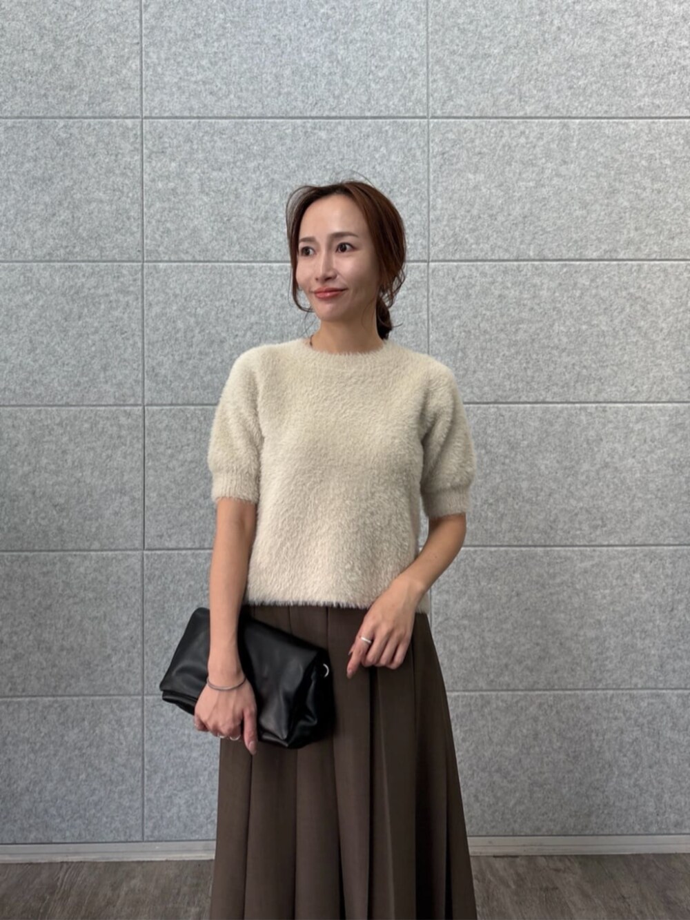 ベージュ系のニット/セーター、ブラウン系のスカートを着用したレディースの秋コーディネートの6枚目の写真
