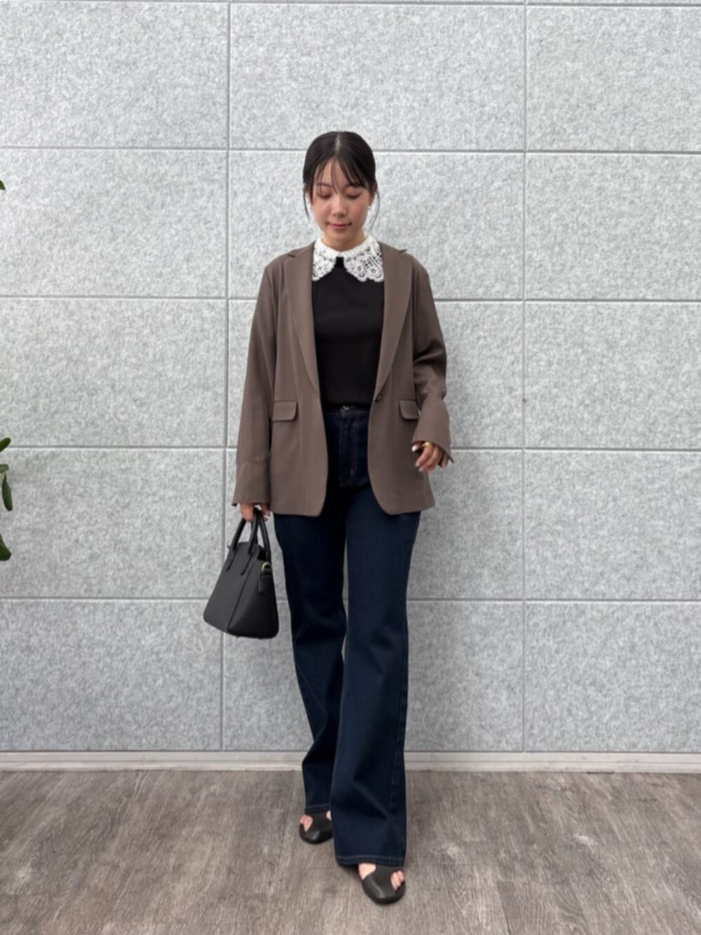 ブラウン系のテーラードジャケット、ブラック系のTシャツ/カットソー、ブルー系のデニムパンツを着用したレディースの秋コーディネートの3枚目の写真