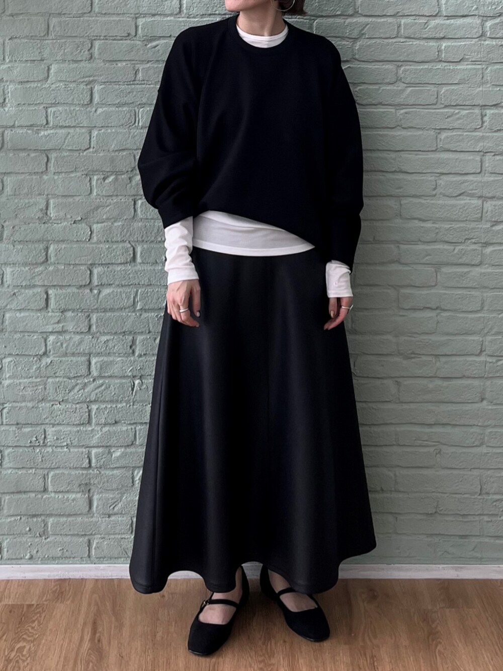 ホワイト系のTシャツ/カットソー、ブラック系のスカート、ブラック系のスウェットを着用したレディースの秋コーディネートの2枚目の写真