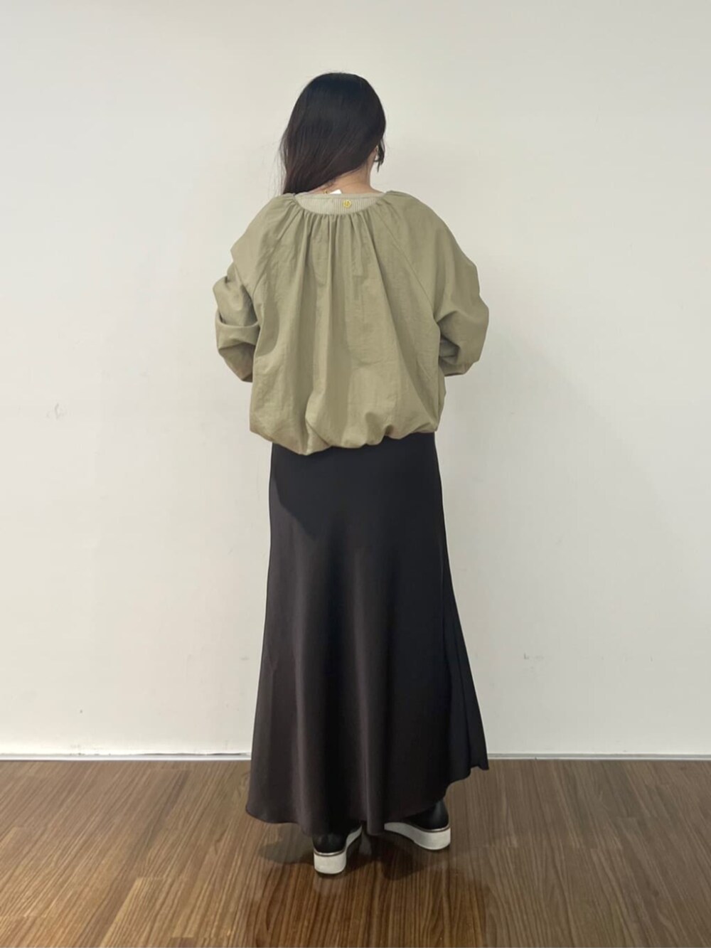 ブラウン系のブルゾン、グレー系のスカート、ベージュ系のニット/セーターを着用したレディースの秋コーディネートの4枚目の写真