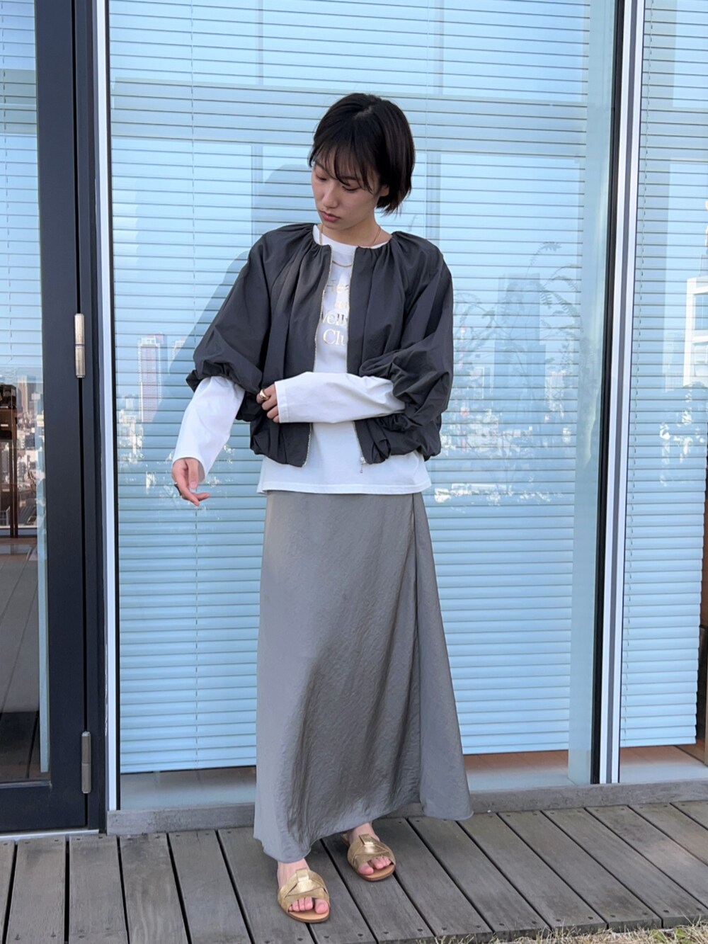 ホワイト系のTシャツ/カットソー、グレー系のブルゾン、グリーン系のスカートを着用したレディースの春コーディネートの4枚目の写真