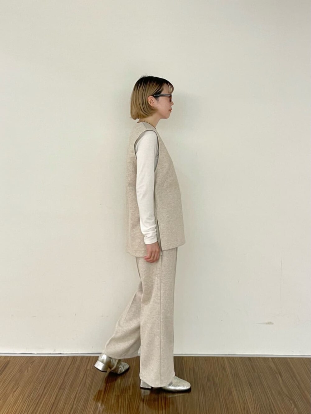 ホワイト系のTシャツ/カットソー、ベージュ系のベスト、ベージュ系のその他パンツを着用したレディースの秋コーディネートの5枚目の写真