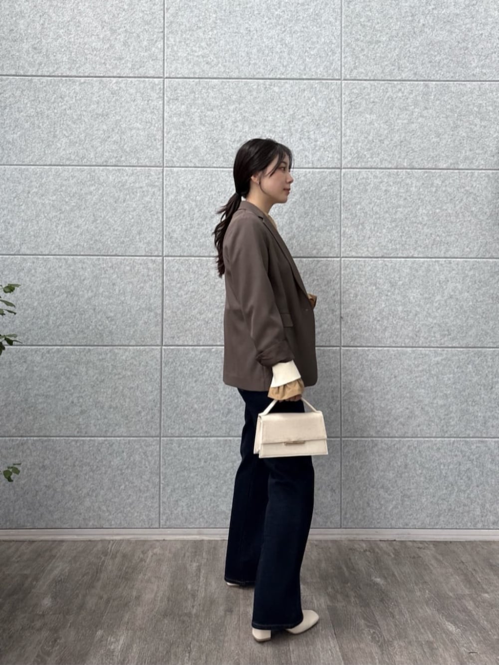 ブラウン系のテーラードジャケット、ブルー系のデニムパンツ、ホワイト系のニット/セーターを着用したレディースの秋コーディネートの5枚目の写真