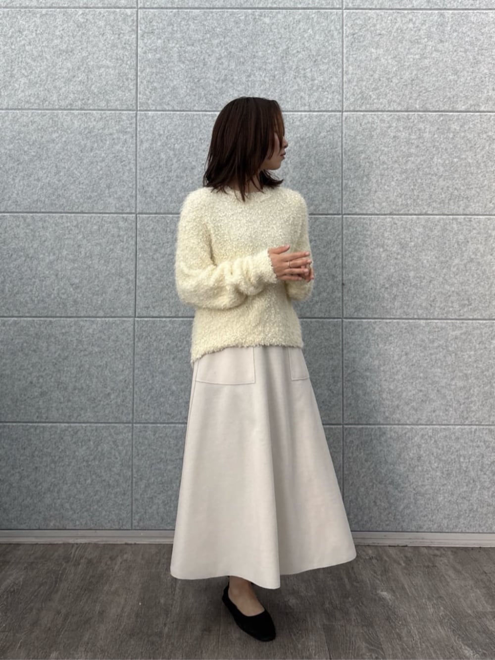 ホワイト系のニット/セーター、ホワイト系のスカートを着用したレディースの冬コーディネートの4枚目の写真