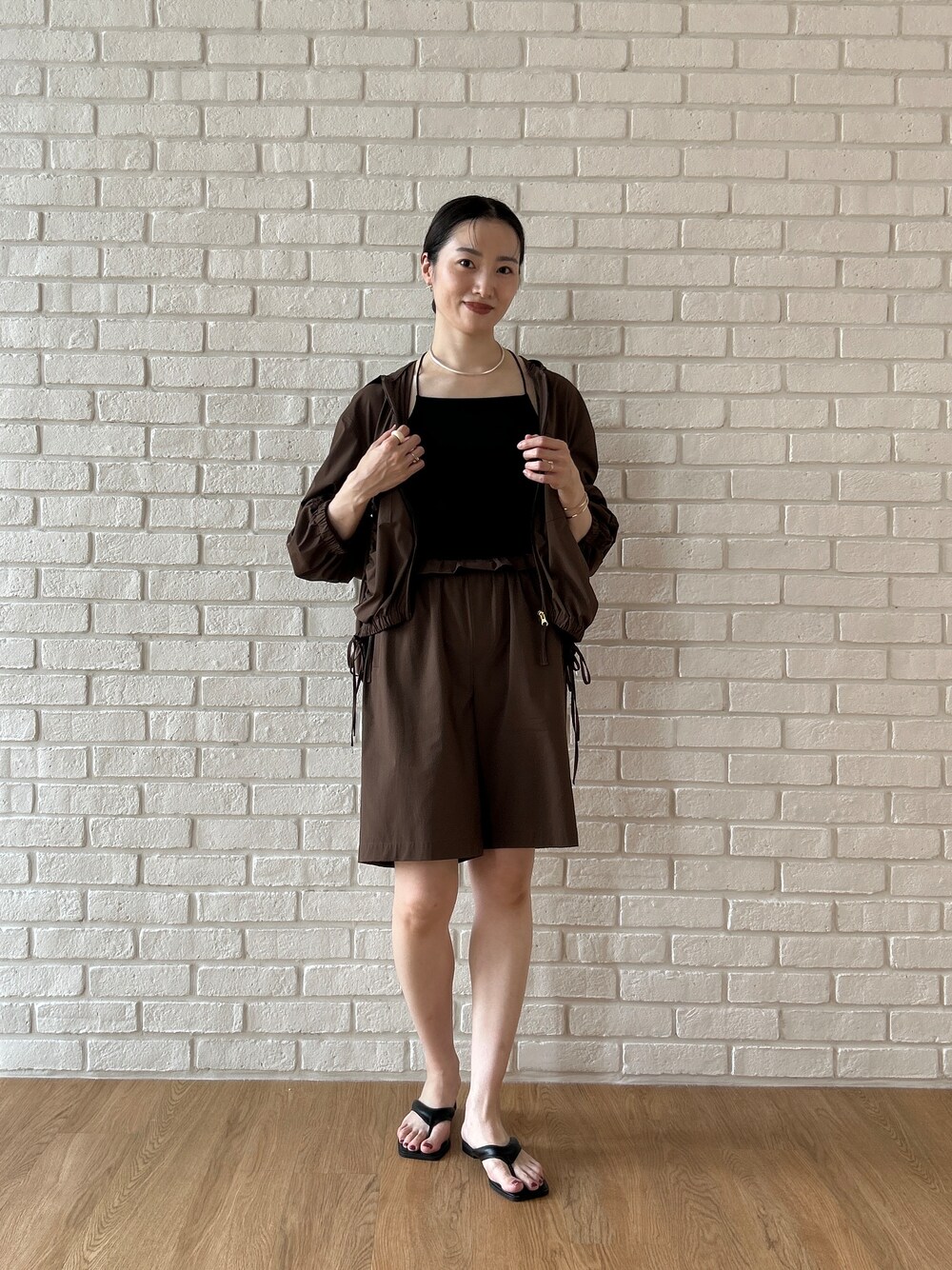 ブラウン系のブルゾン、ブラック系のタンクトップ、ブラウン系のその他パンツを着用したレディースの春コーディネートの2枚目の写真