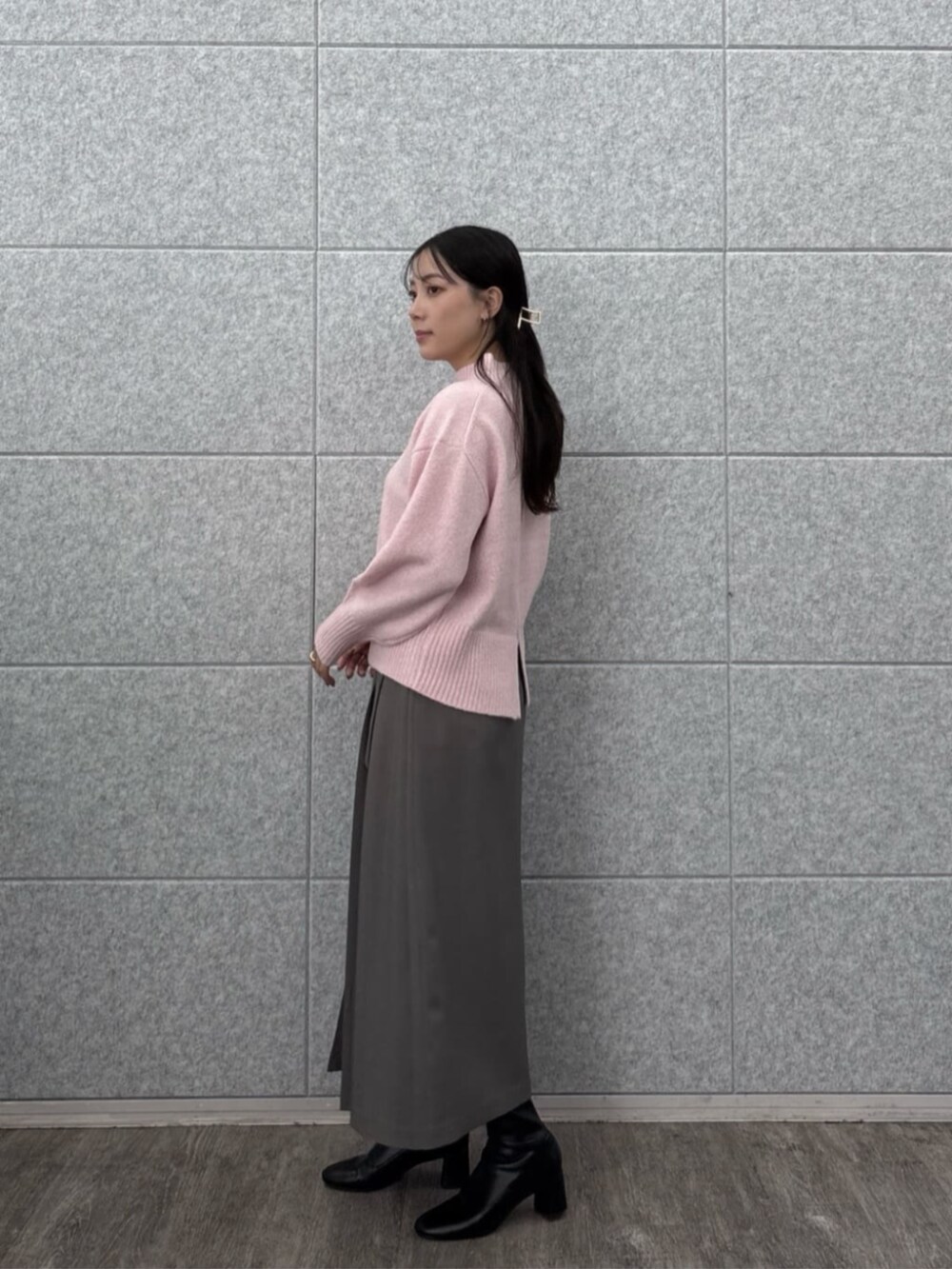 グレー系のスカート、ピンク系のニット/セーターを着用したレディースの秋コーディネートの3枚目の写真