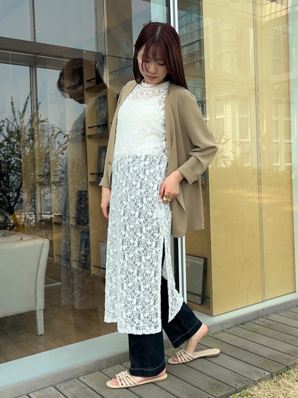 ブルー系のデニムパンツ、ベージュ系のノーカラージャケット、ホワイト系のタンクトップを着用したレディースの春コーディネートの5枚目の写真