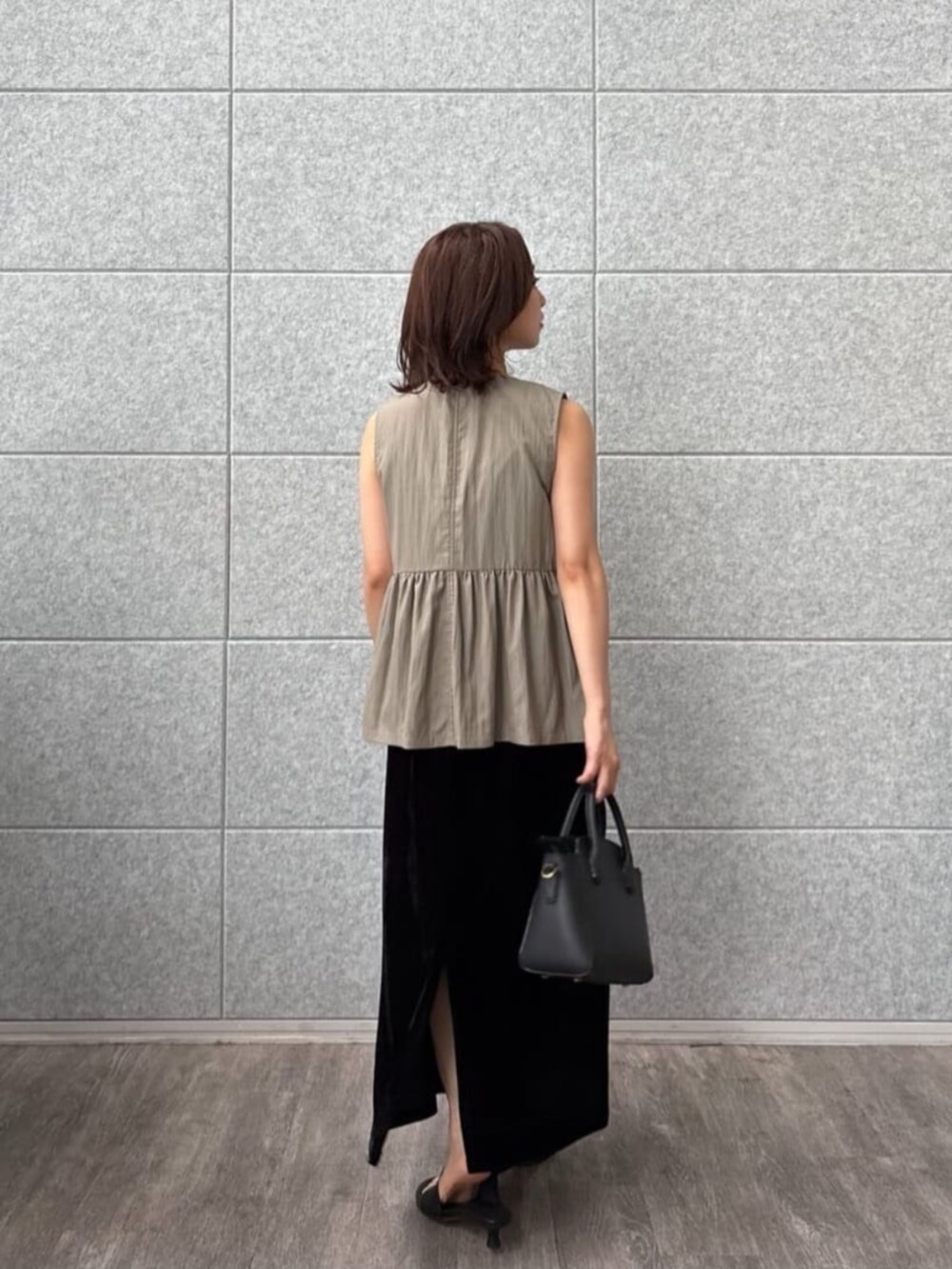 グリーン系のベストを着用したレディースの秋コーディネートの3枚目の写真