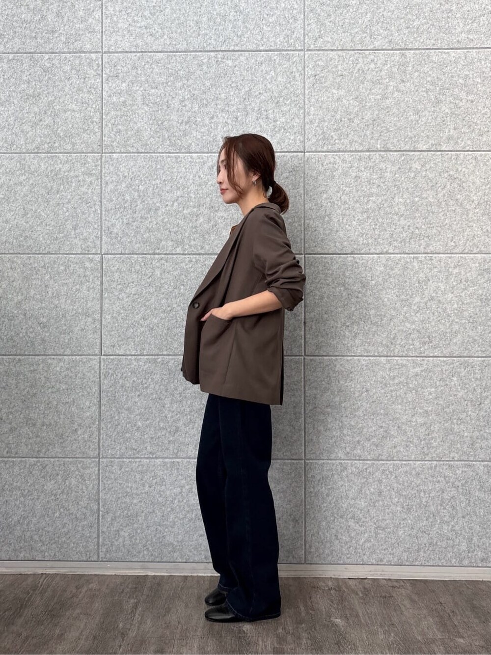 ブラウン系のテーラードジャケット、イエロー系のTシャツ/カットソー、ブルー系のデニムパンツを着用したレディースの秋コーディネートの5枚目の写真