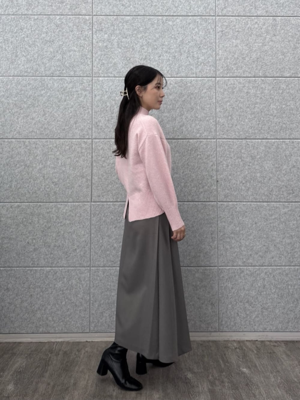 グレー系のスカート、ピンク系のニット/セーターを着用したレディースの秋コーディネートの2枚目の写真