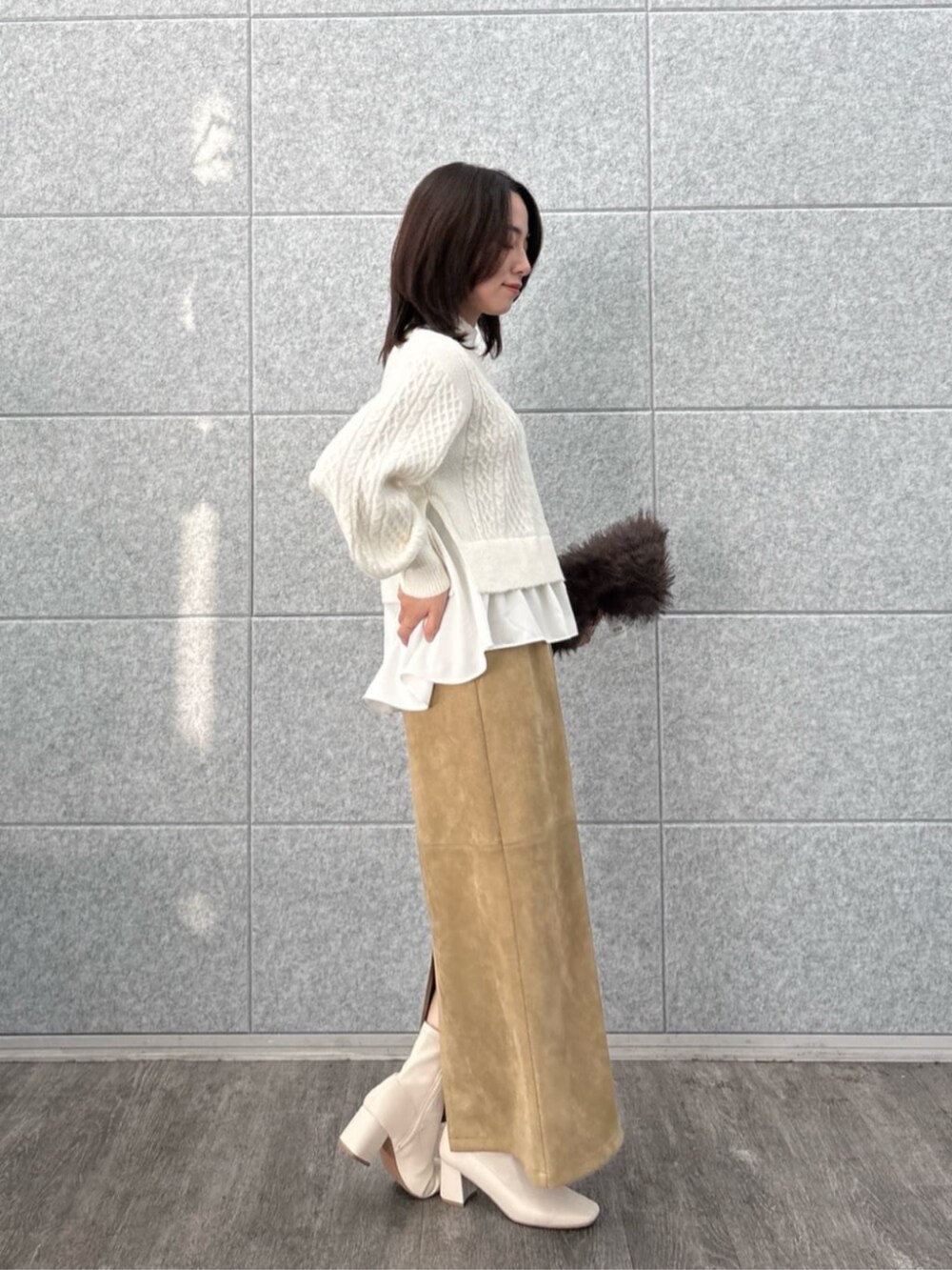 ホワイト系のニット/セーター、ブラウン系のスカートを着用したレディースの冬コーディネートの5枚目の写真