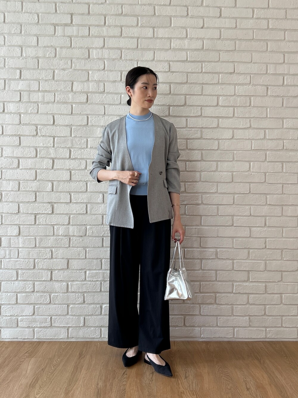 ブルー系のニット/セーター、グレー系のノーカラージャケット、ブラック系のその他パンツを着用したレディースの春コーディネートの2枚目の写真