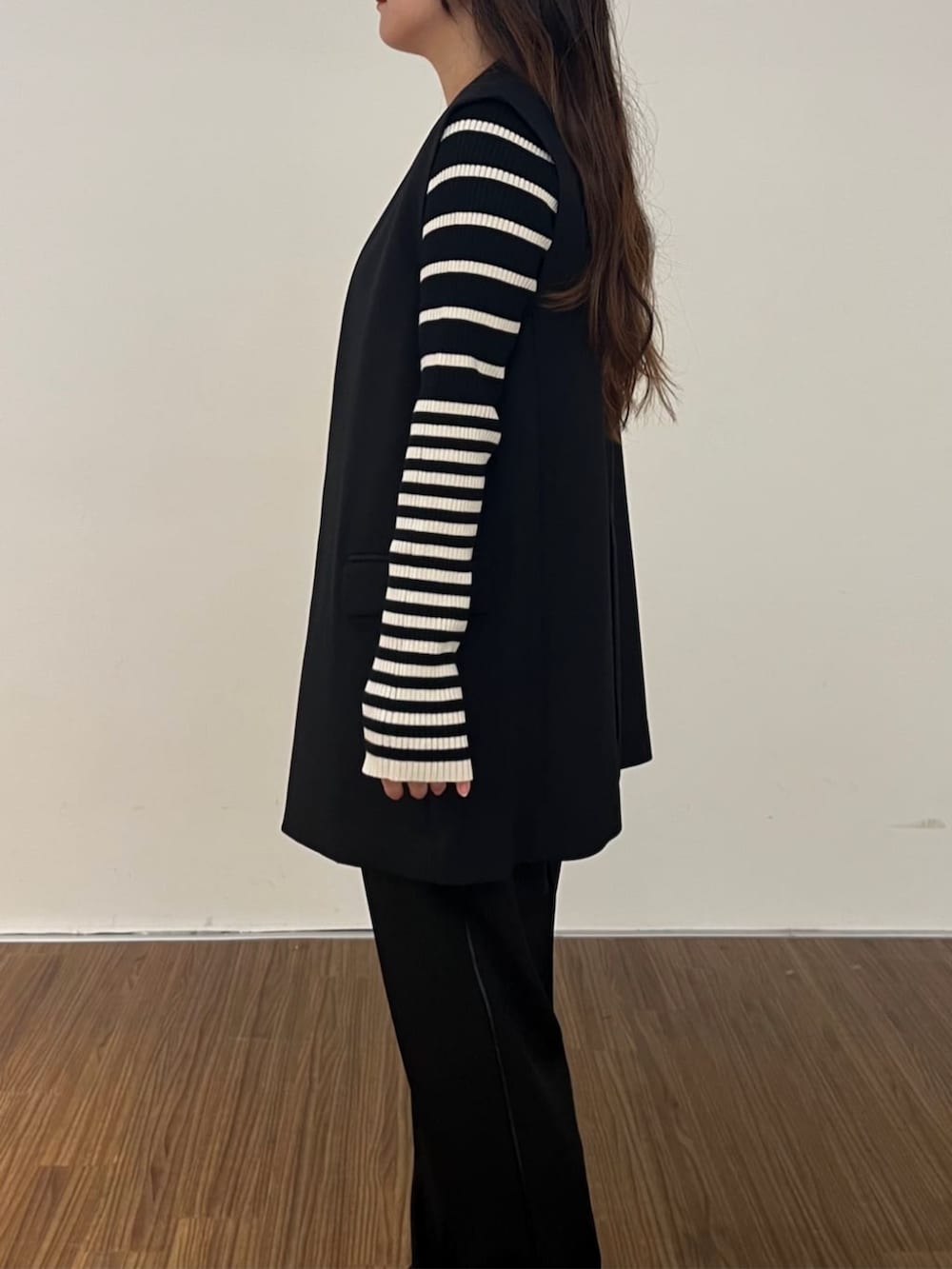 ブラック系のニット/セーター、ブラック系のその他パンツ、ブラック系のベストを着用したレディースの秋コーディネートの6枚目の写真