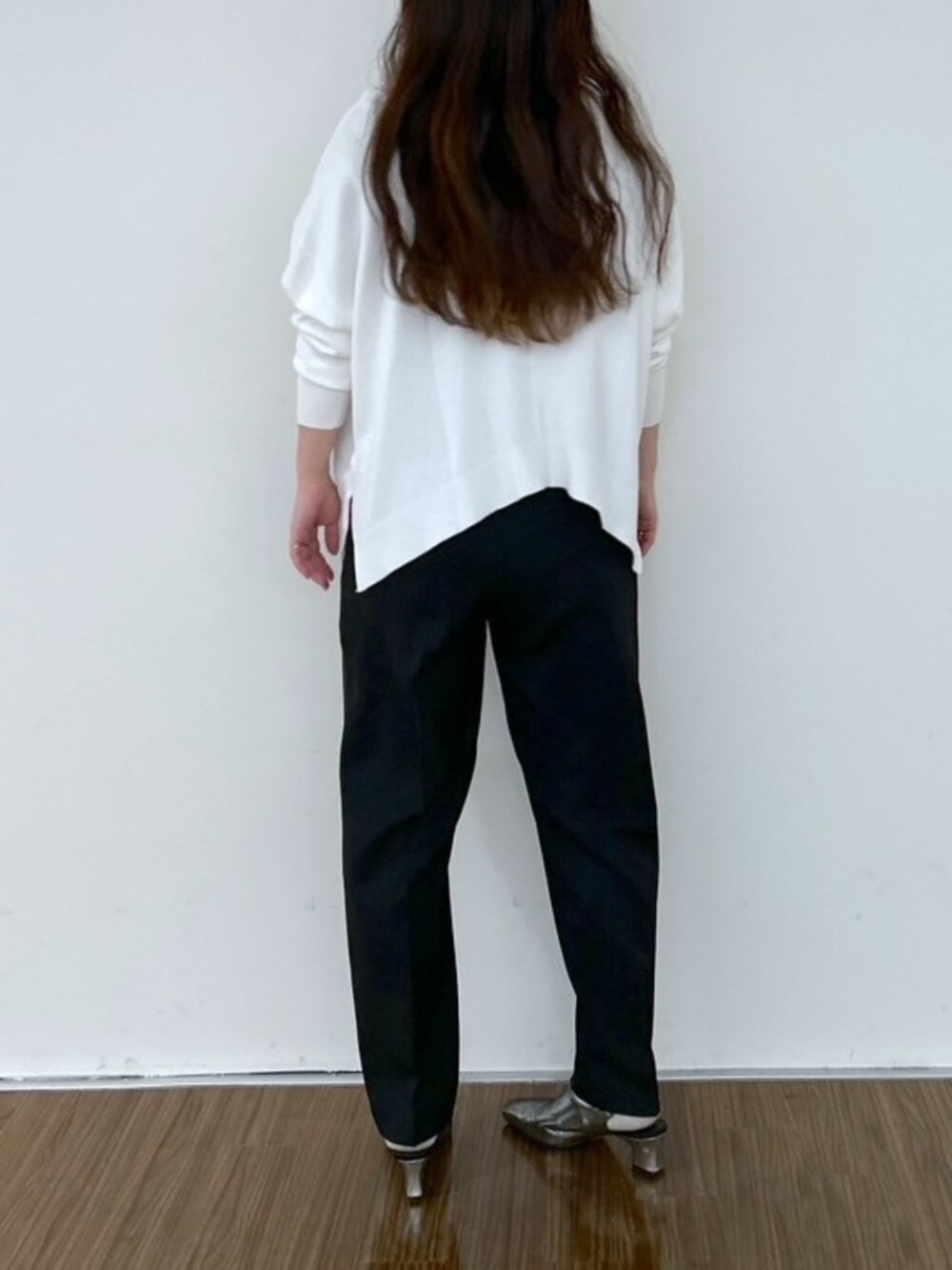 ホワイト系のニット/セーター、ブラック系のその他パンツを着用したレディースの春コーディネートの4枚目の写真