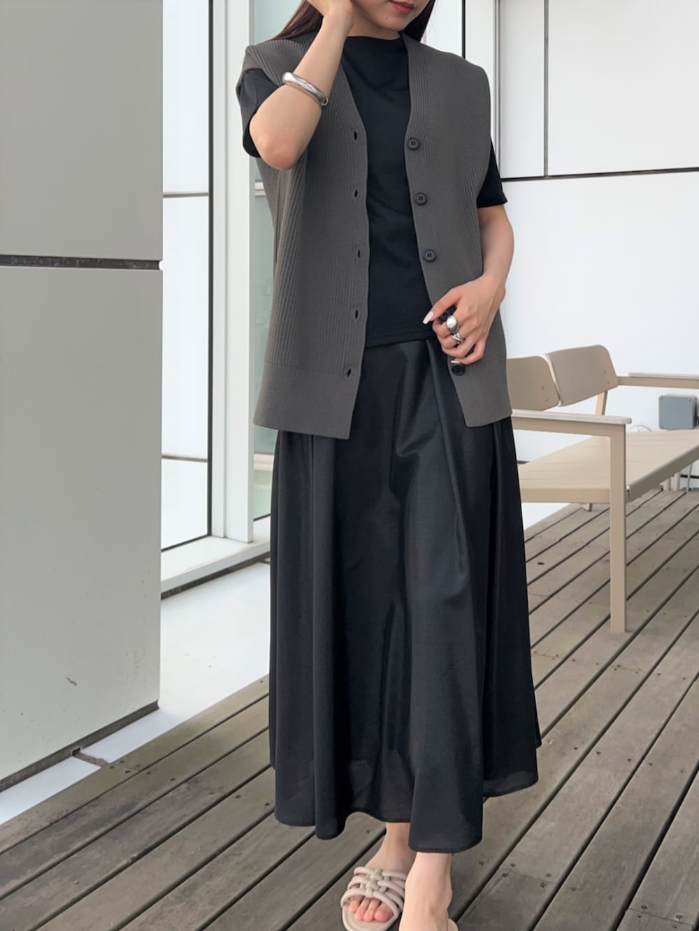 グレー系のベスト、ブラック系のスカート、ブラック系のTシャツ/カットソーを着用したレディースの春コーディネートの6枚目の写真