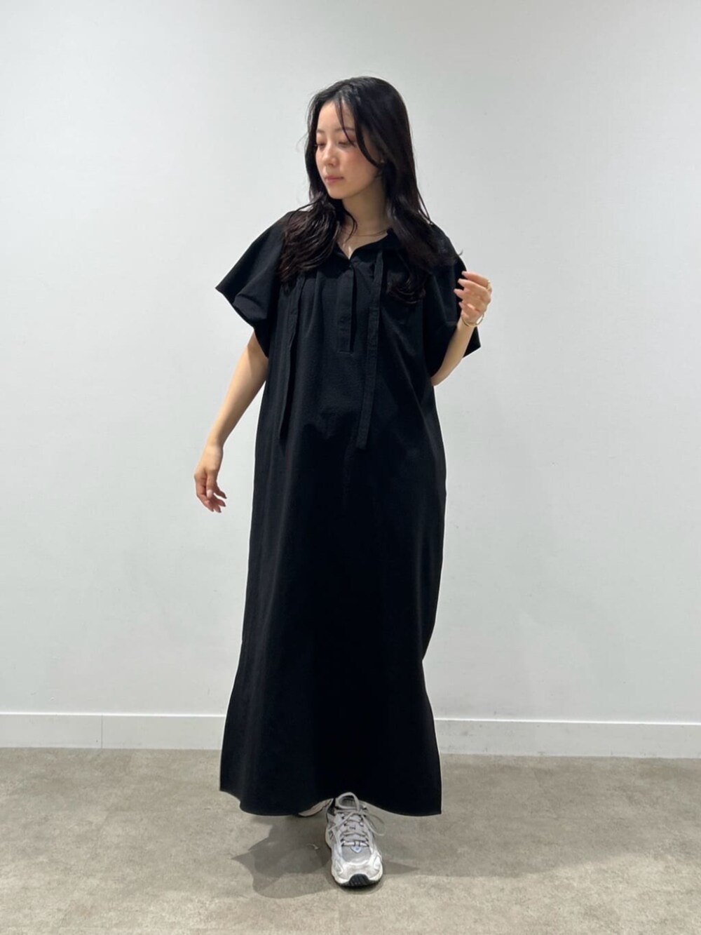 ブラック系のワンピースを着用したレディースの春コーディネートの2枚目の写真