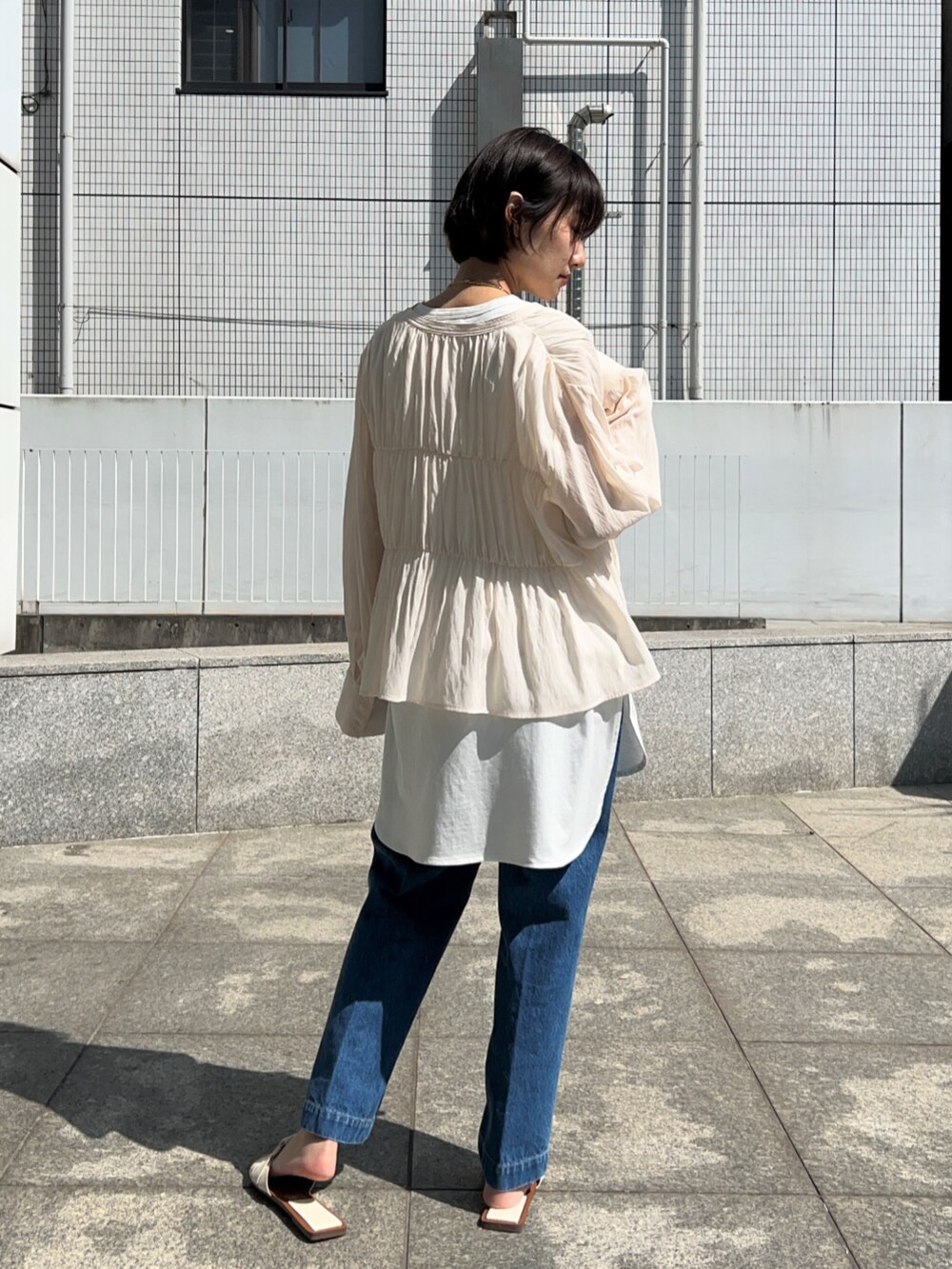 ブルー系のデニムパンツ、ホワイト系のシャツ/ブラウス、ホワイト系のTシャツ/カットソーを着用したレディースの春コーディネートの2枚目の写真