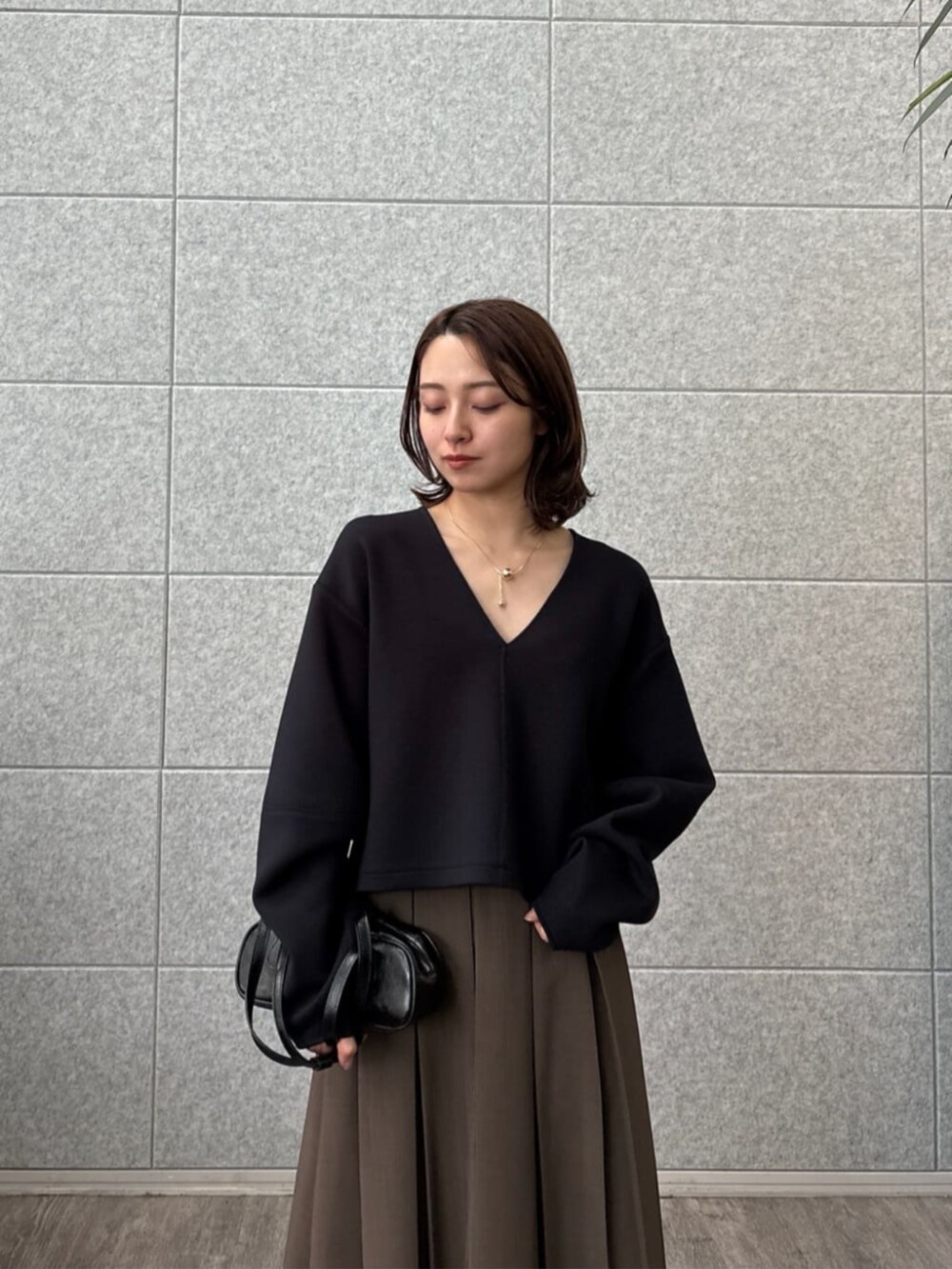 ブラウン系のスカート、ブラック系のTシャツ/カットソーを着用したレディースの秋コーディネートの6枚目の写真