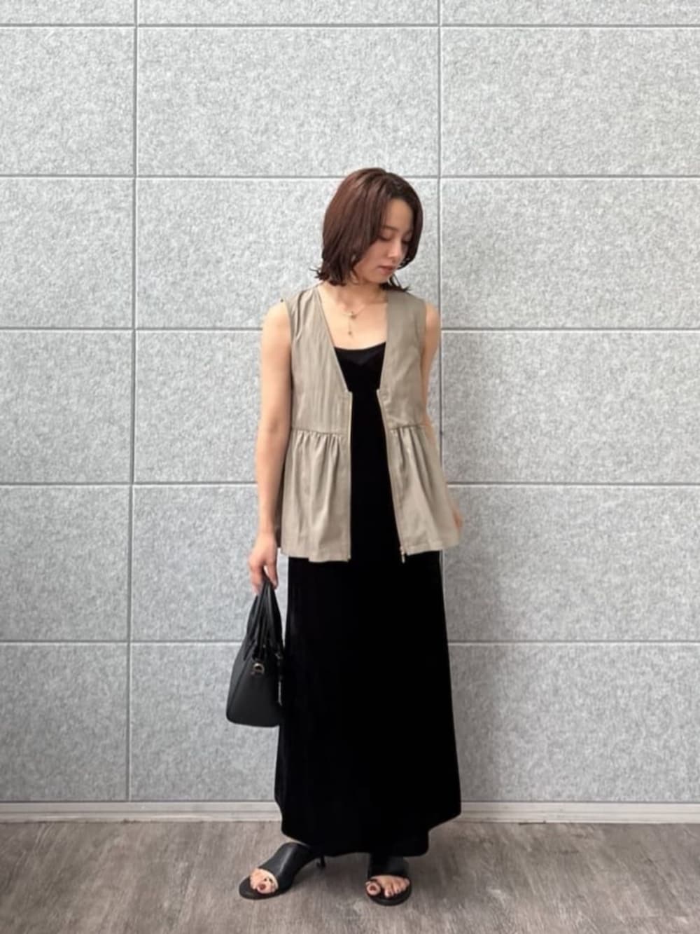 グリーン系のベストを着用したレディースの秋コーディネートの6枚目の写真