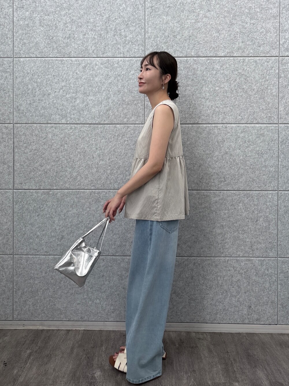ベージュ系のシャツ/ブラウス、ブルー系のデニムパンツを着用したレディースの夏コーディネートの2枚目の写真