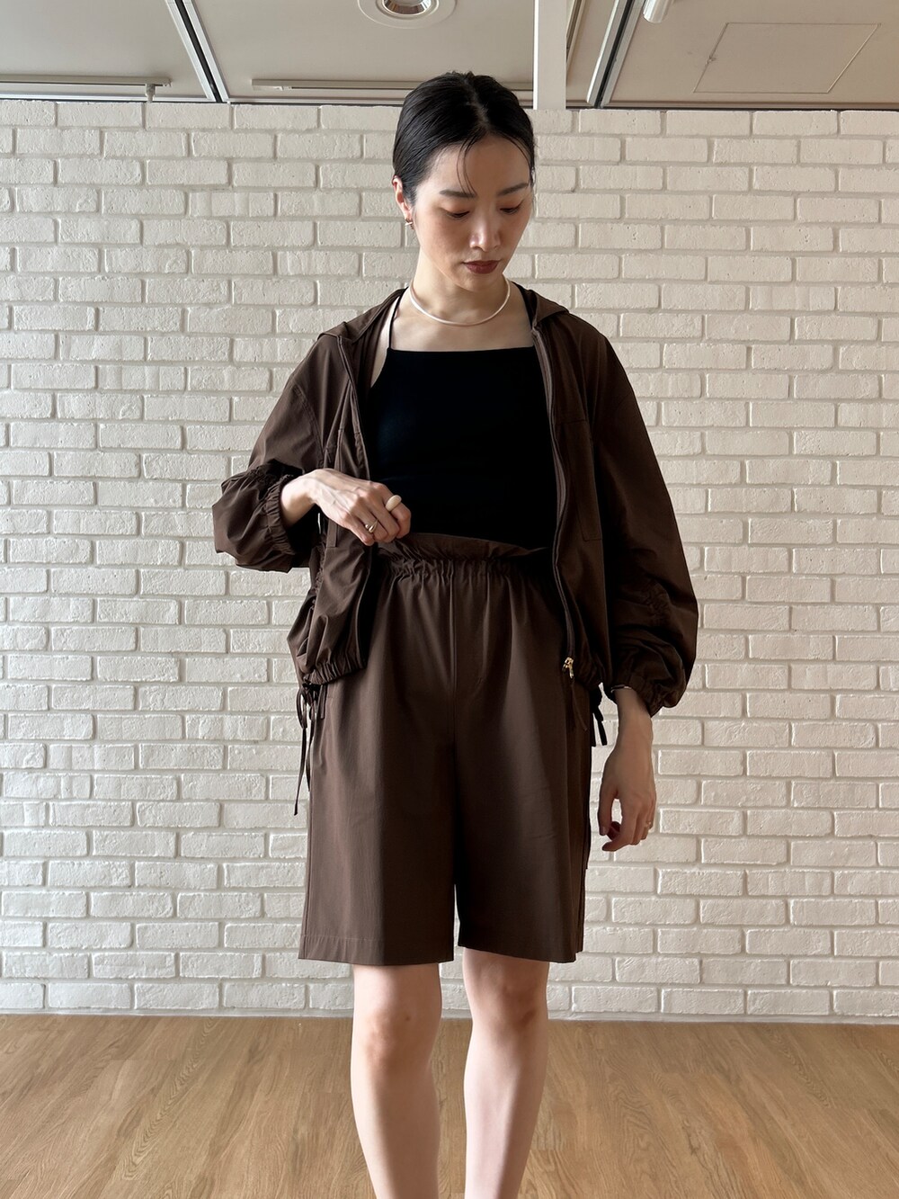 ブラウン系のブルゾン、ブラック系のタンクトップ、ブラウン系のその他パンツを着用したレディースの春コーディネートの9枚目の写真