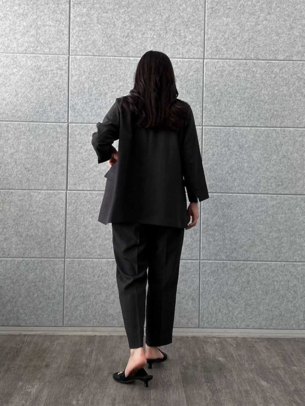 ホワイト系のタンクトップ、ブラック系のテーラードジャケット、ブラック系のその他パンツを着用したレディースの夏コーディネートの2枚目の写真