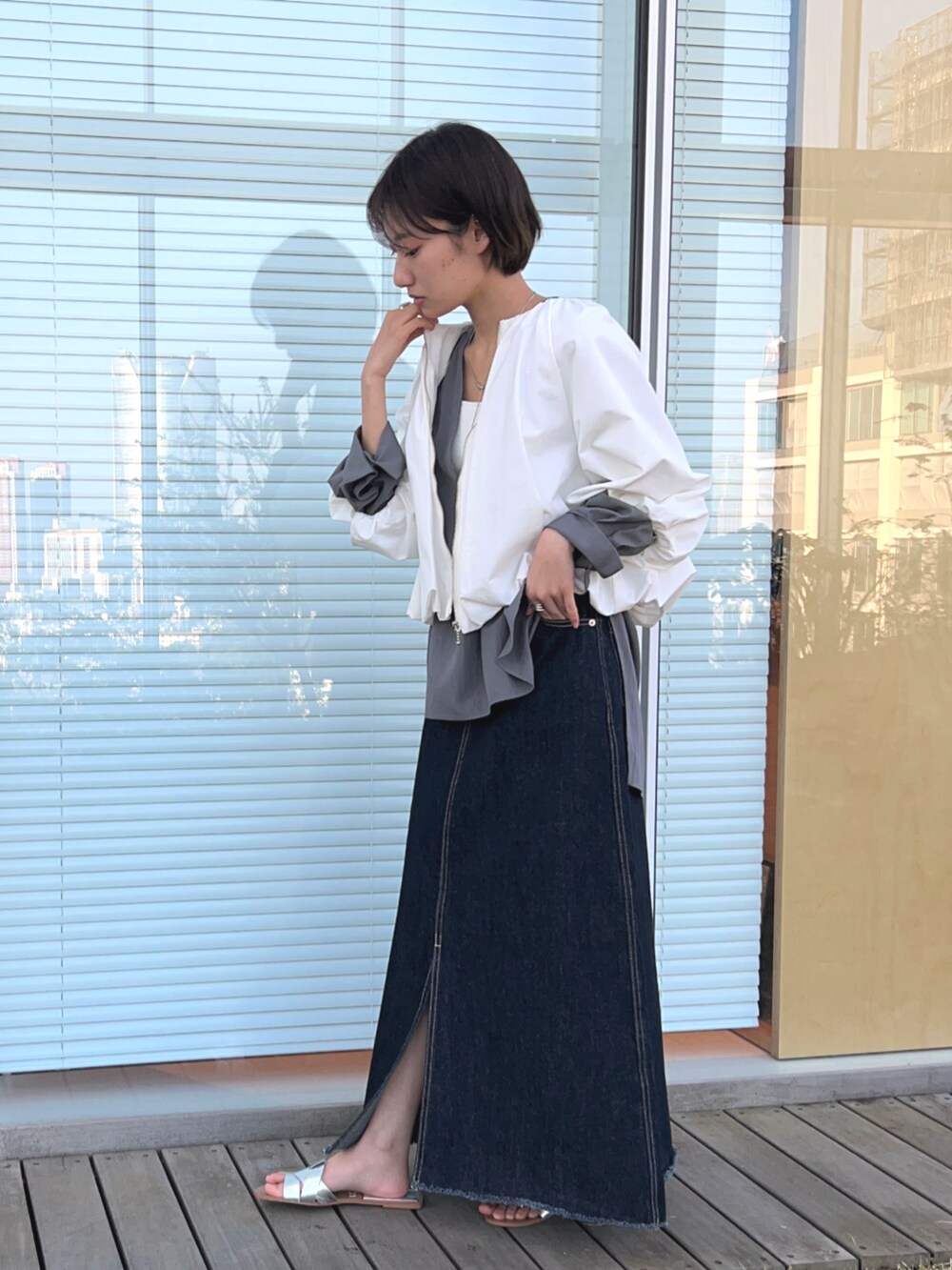 ブルー系のデニムスカート、ホワイト系のブルゾン、グレー系のシャツ/ブラウスを着用したレディースの春コーディネートの4枚目の写真