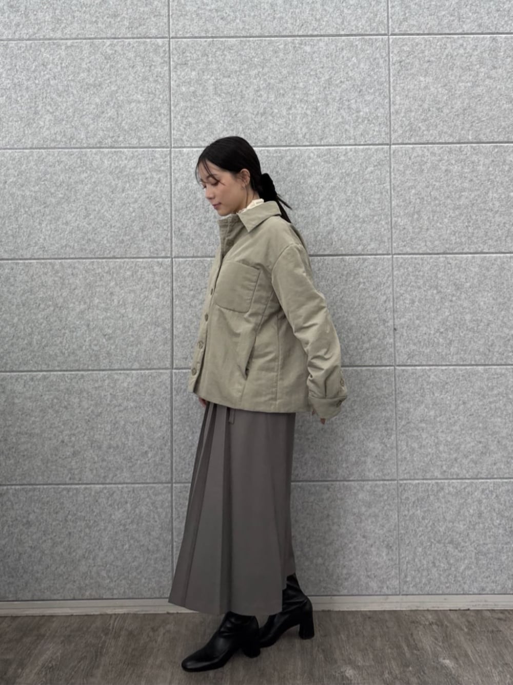 グレー系のスカート、ホワイト系のTシャツ/カットソー、グリーン系のブルゾンを着用したレディースの秋コーディネートの3枚目の写真