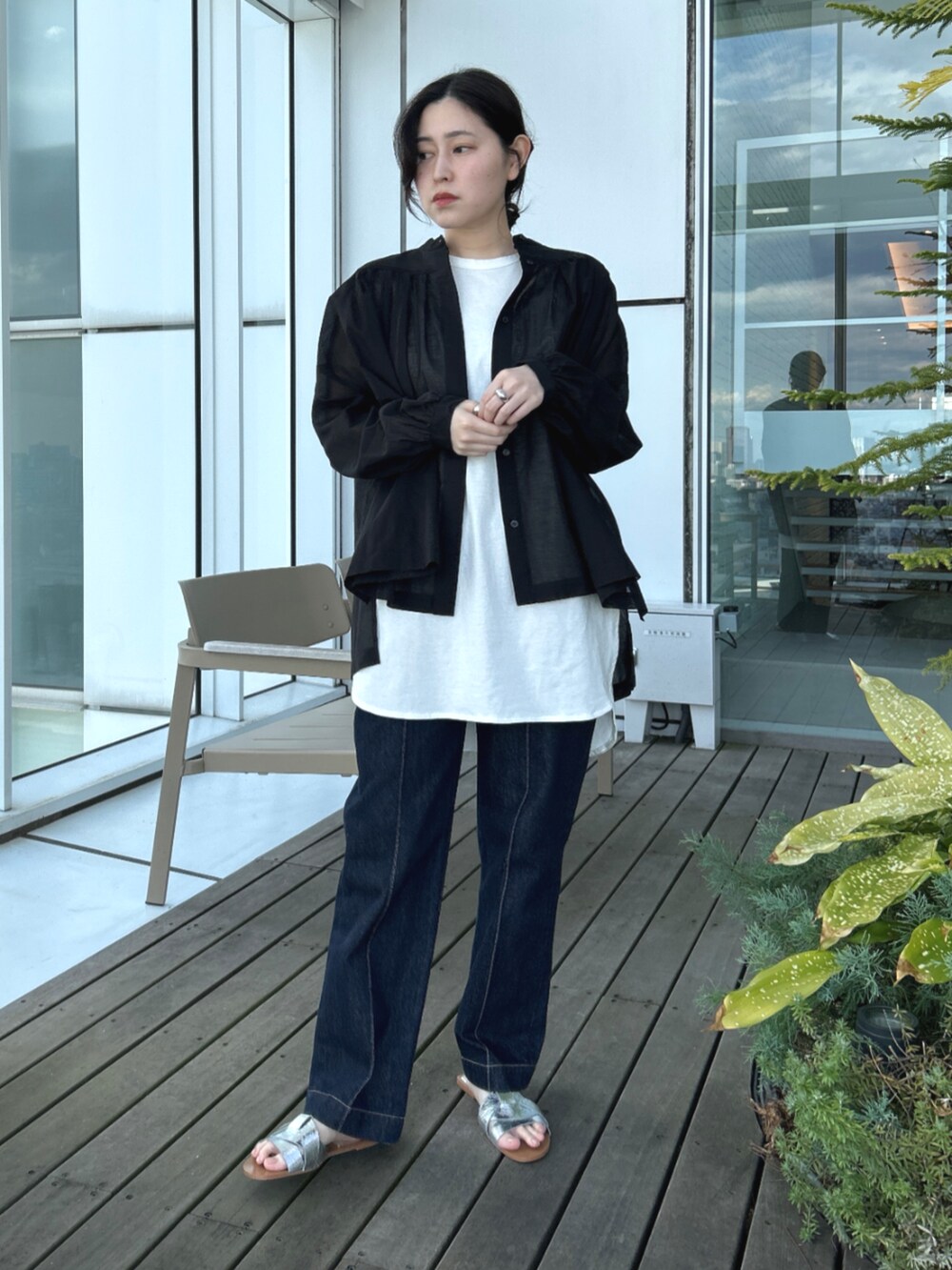 ブルー系のデニムパンツ、ホワイト系のTシャツ/カットソー、ブラック系のシャツ/ブラウスを着用したレディースの春コーディネートの2枚目の写真