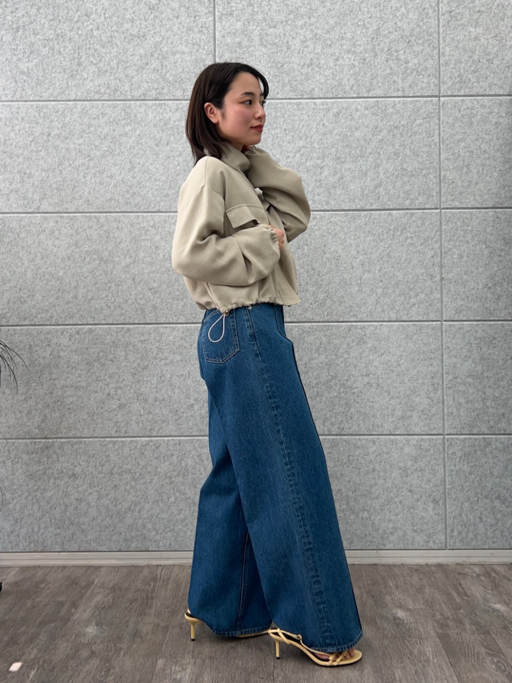 ブルー系のデニムパンツ、グリーン系のブルゾンを着用したレディースの春コーディネートの5枚目の写真