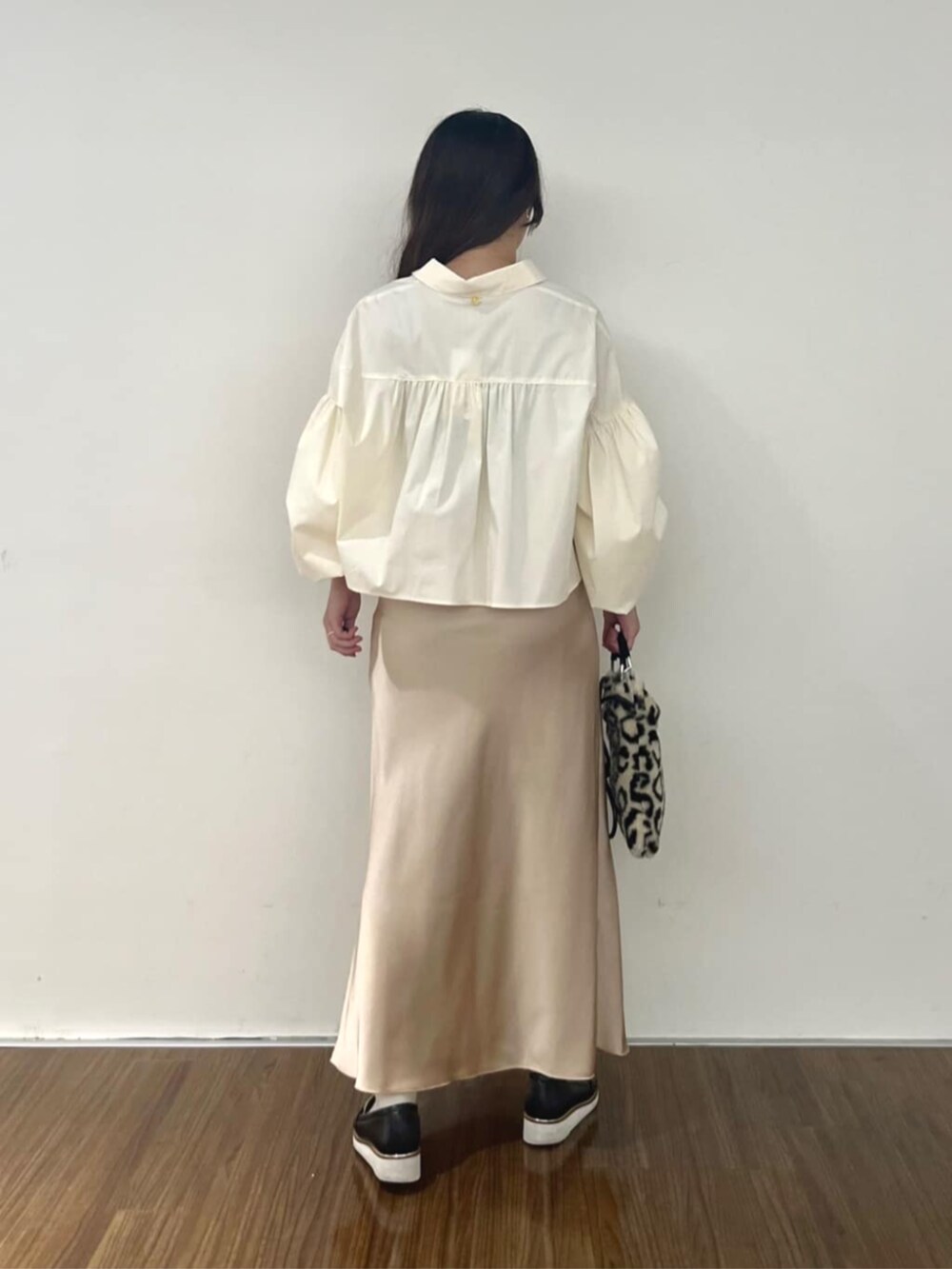 ベージュ系のスカート、ホワイト系のシャツ/ブラウスを着用したレディースの秋コーディネートの3枚目の写真