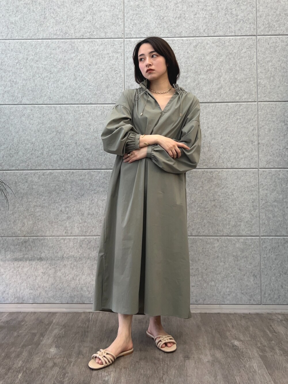 グリーン系のワンピースを着用したレディースの春コーディネートの2枚目の写真